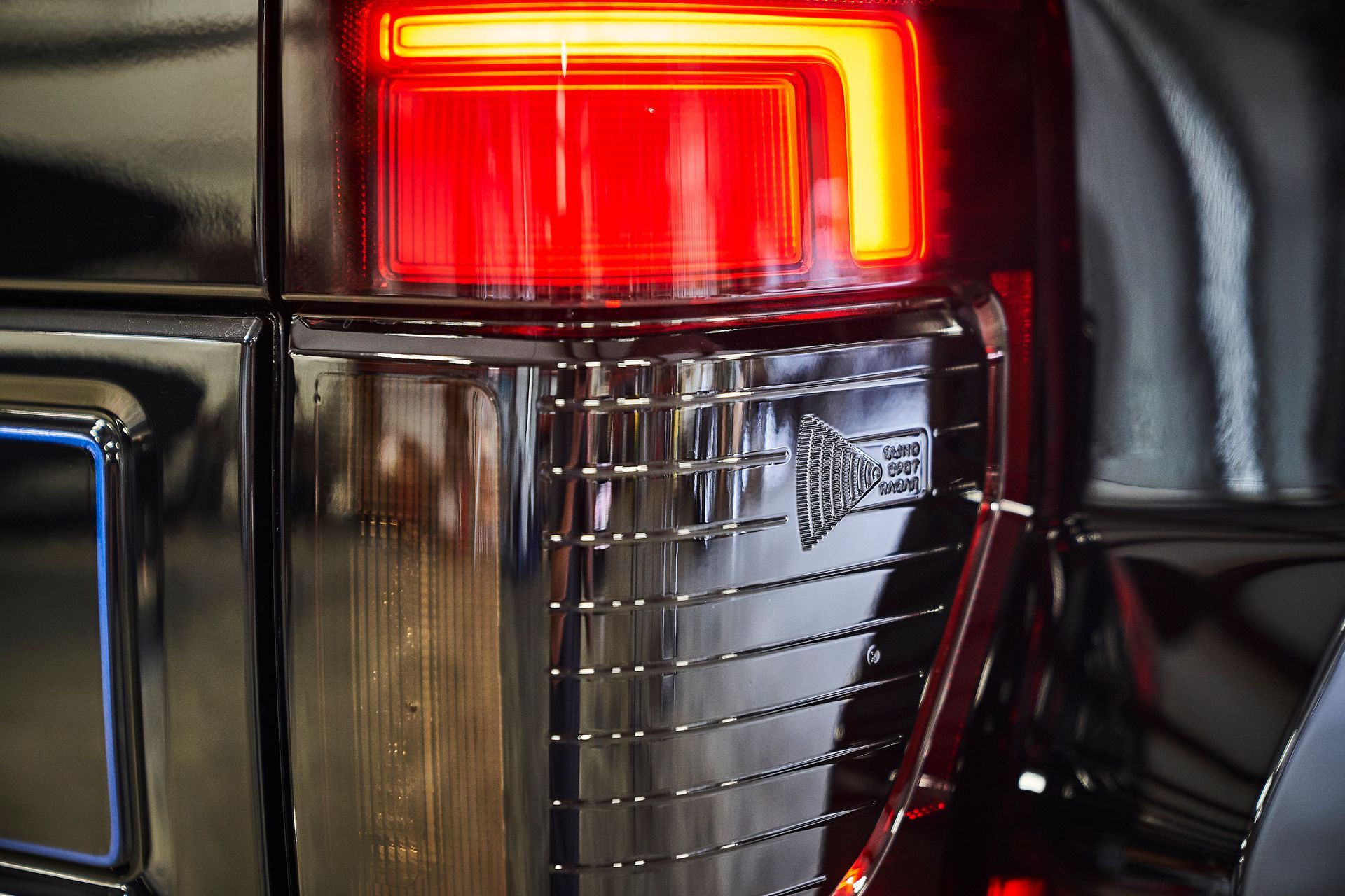 A close up of a black car 's tail light.