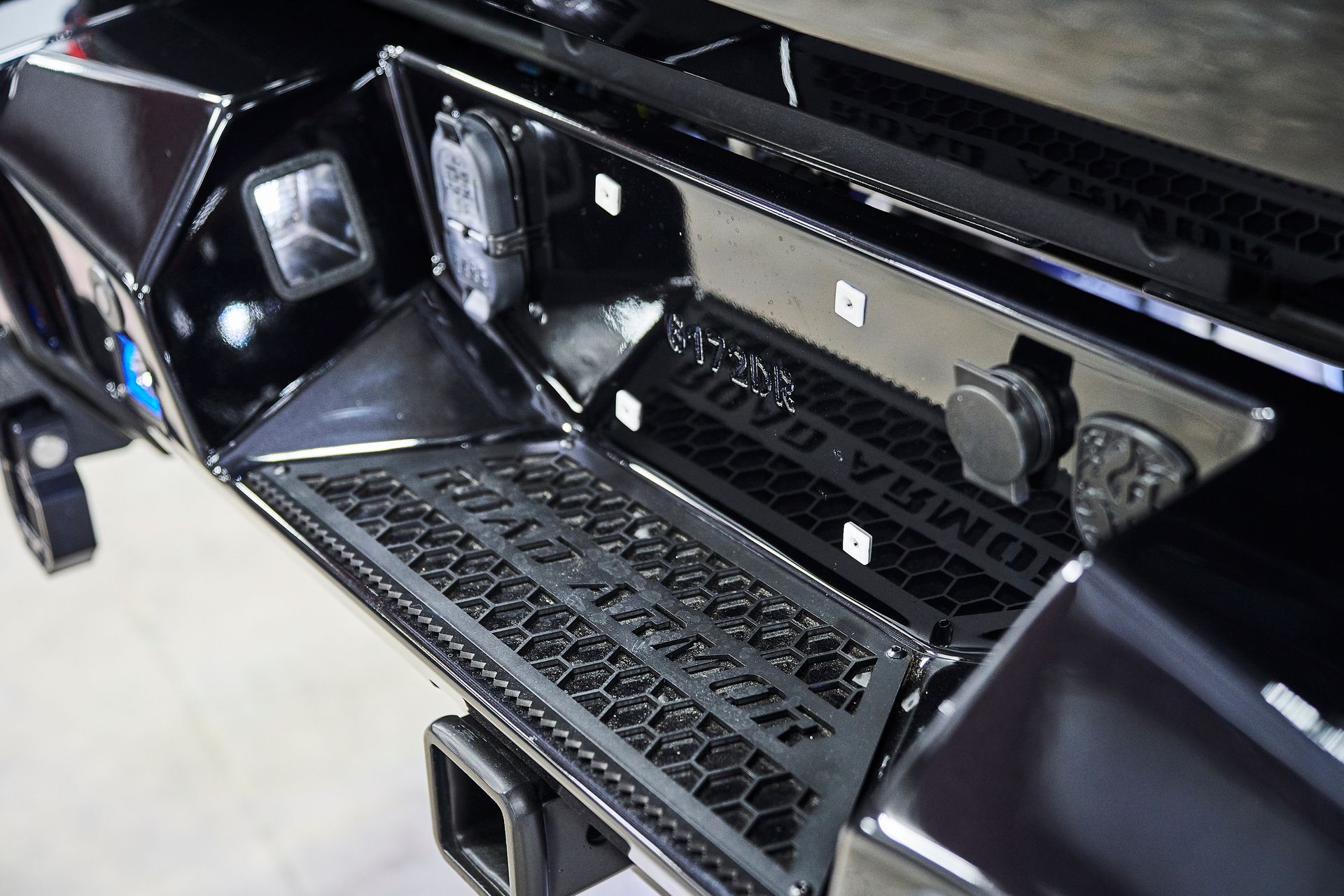 A close up of a black car 's rear bumper with lights on it
