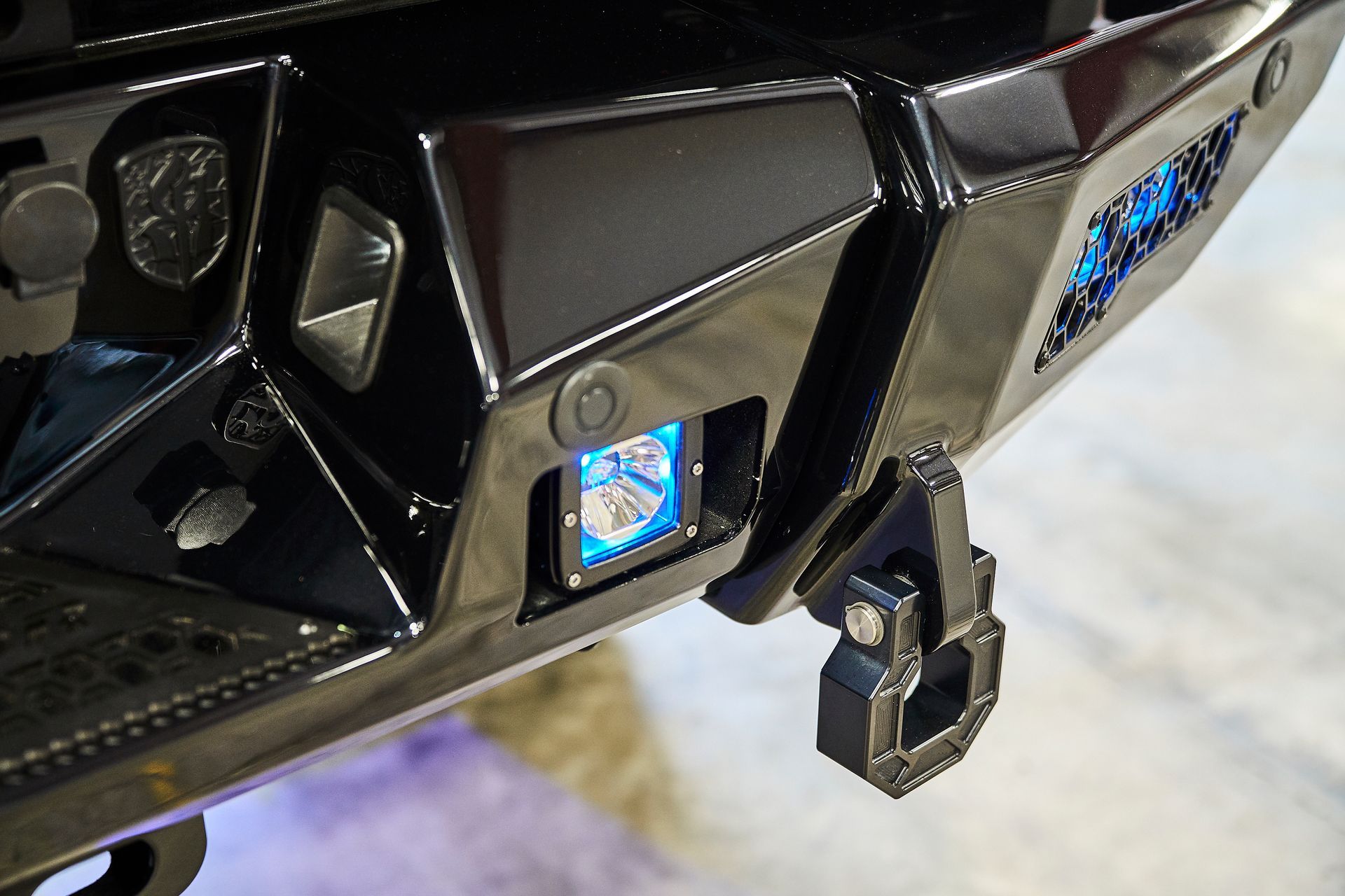 A close up of a black bumper with a blue light on it