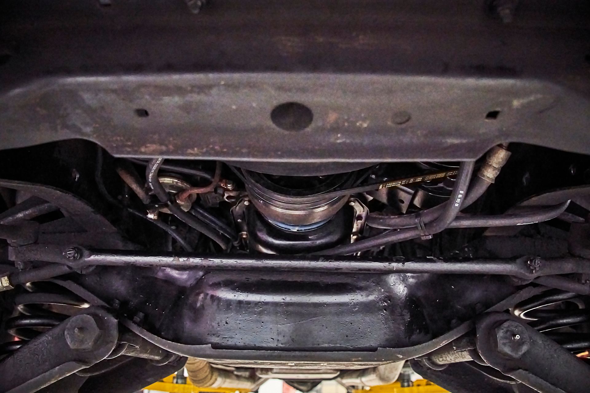 A close up of the underside of a car in a garage.