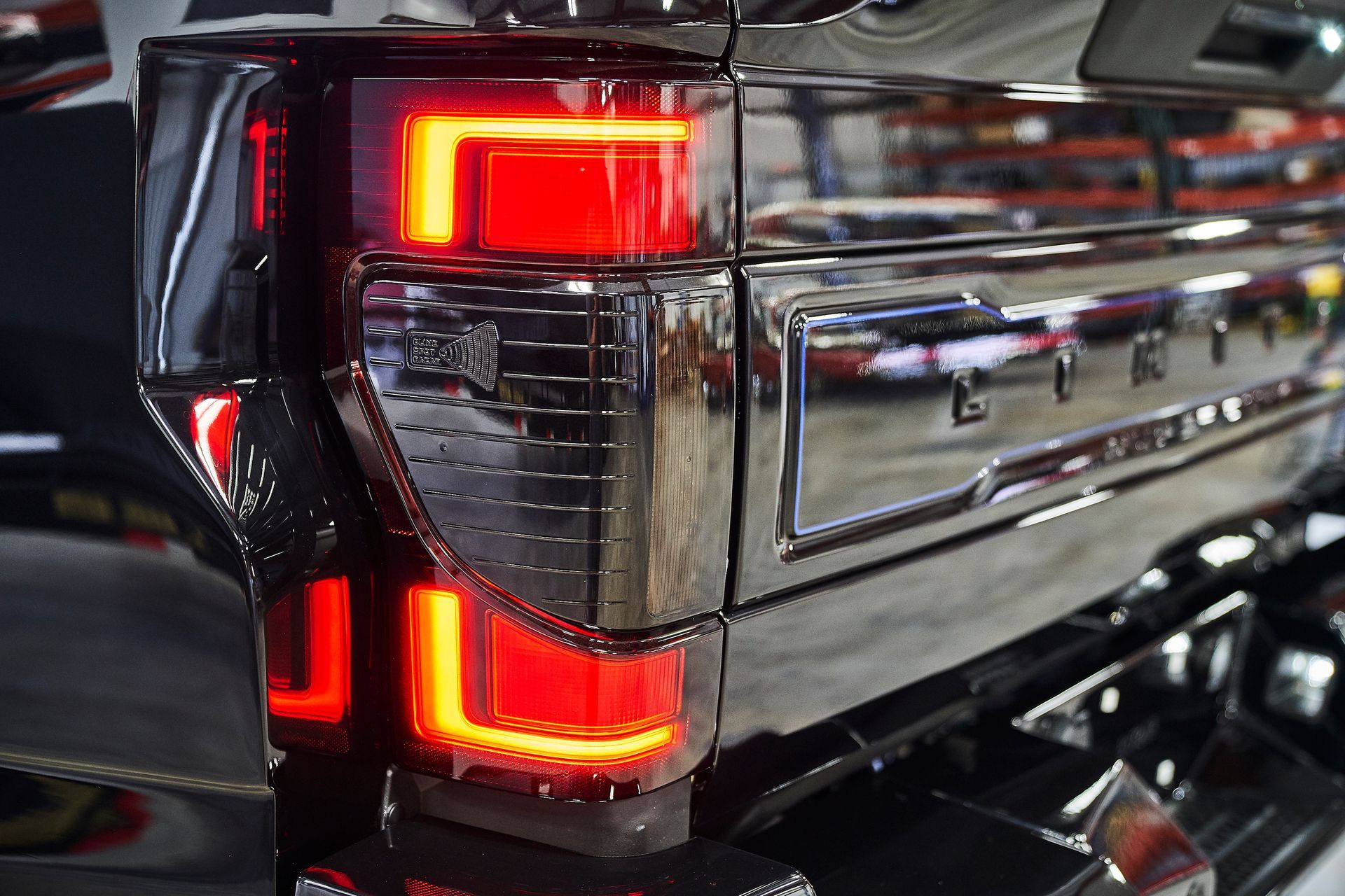 A close up of a black truck 's tail light.