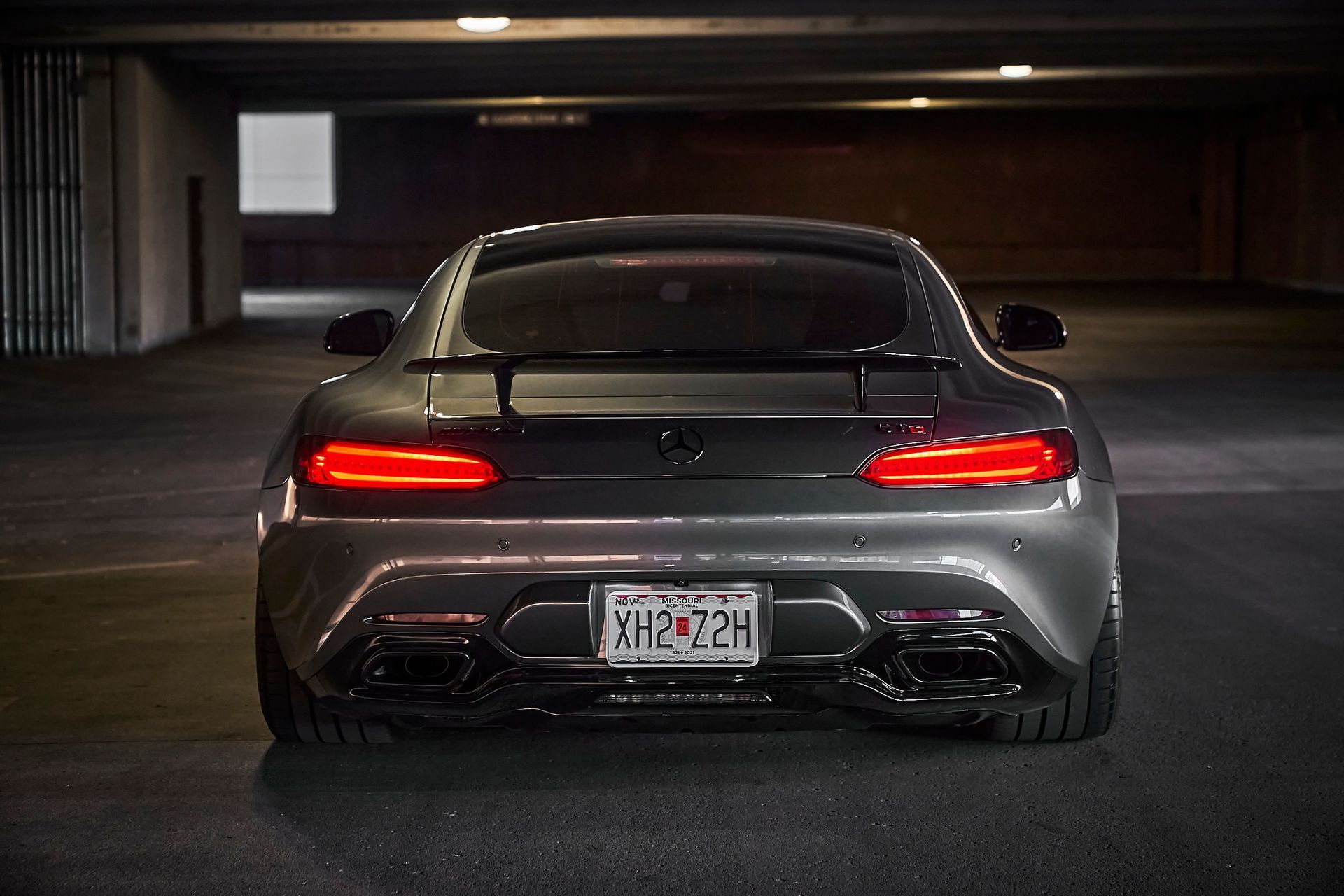 A black sports car is parked in a parking garage.