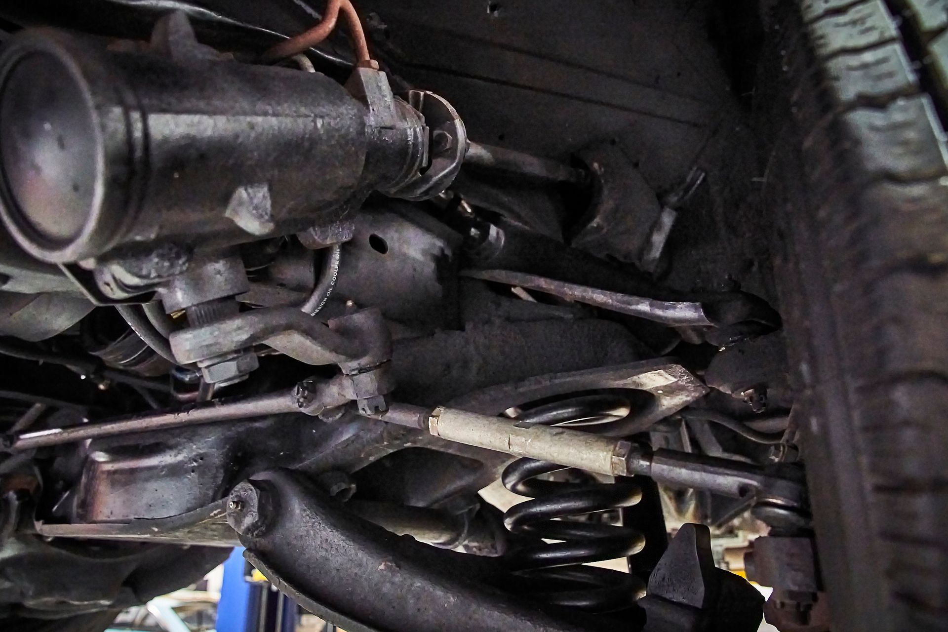 A close up of the underside of a car on a lift.