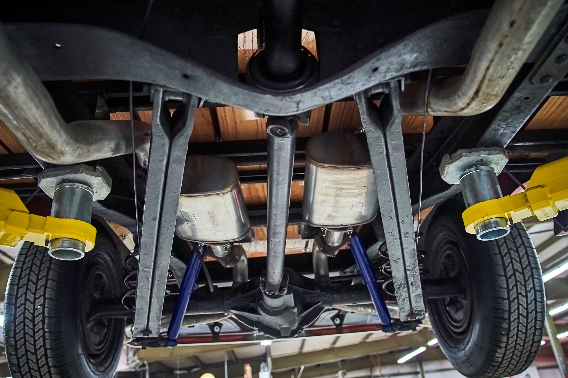 The underside of a truck is shown in a garage