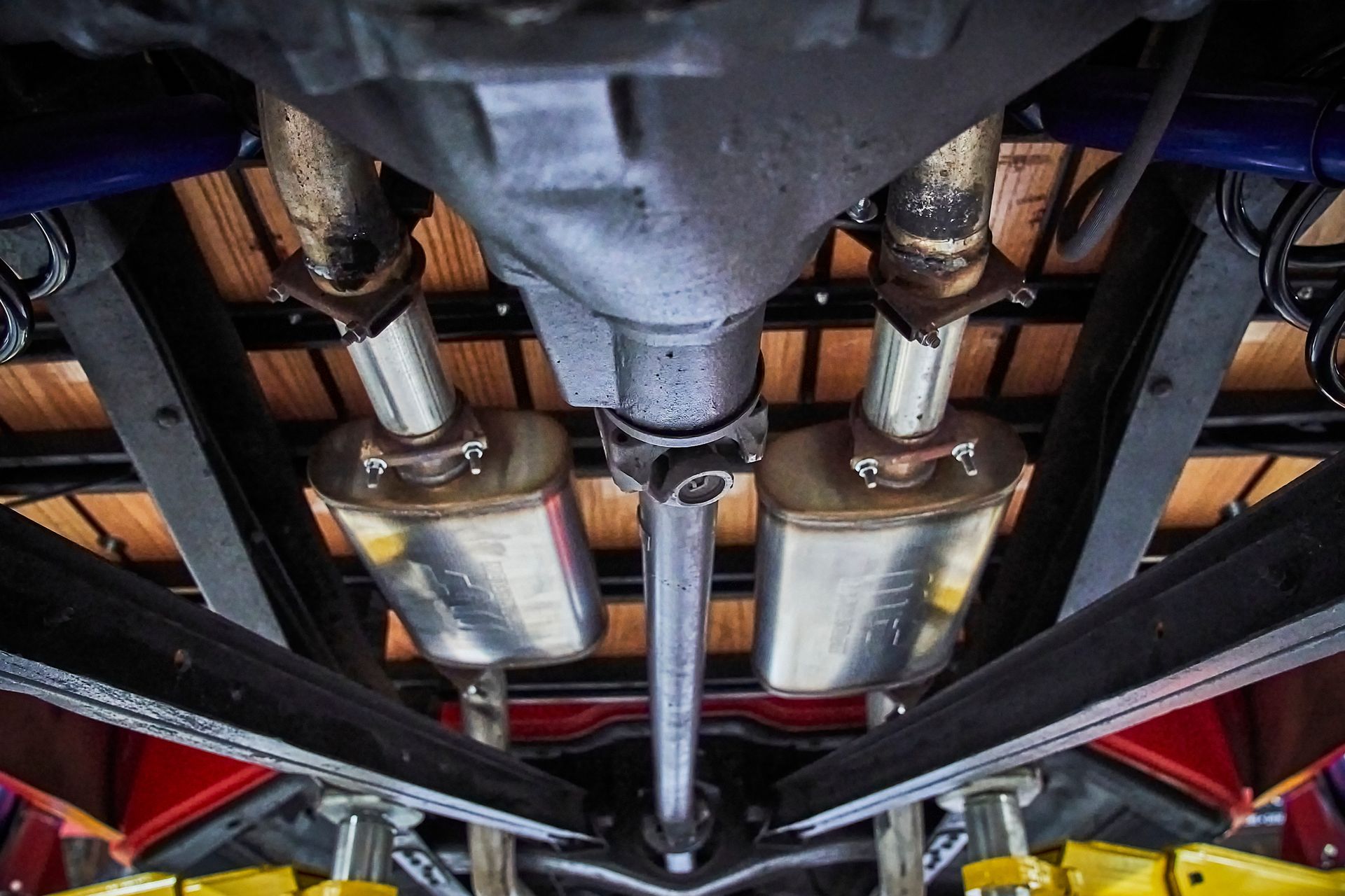 A close up of the underside of a car with exhaust pipes.