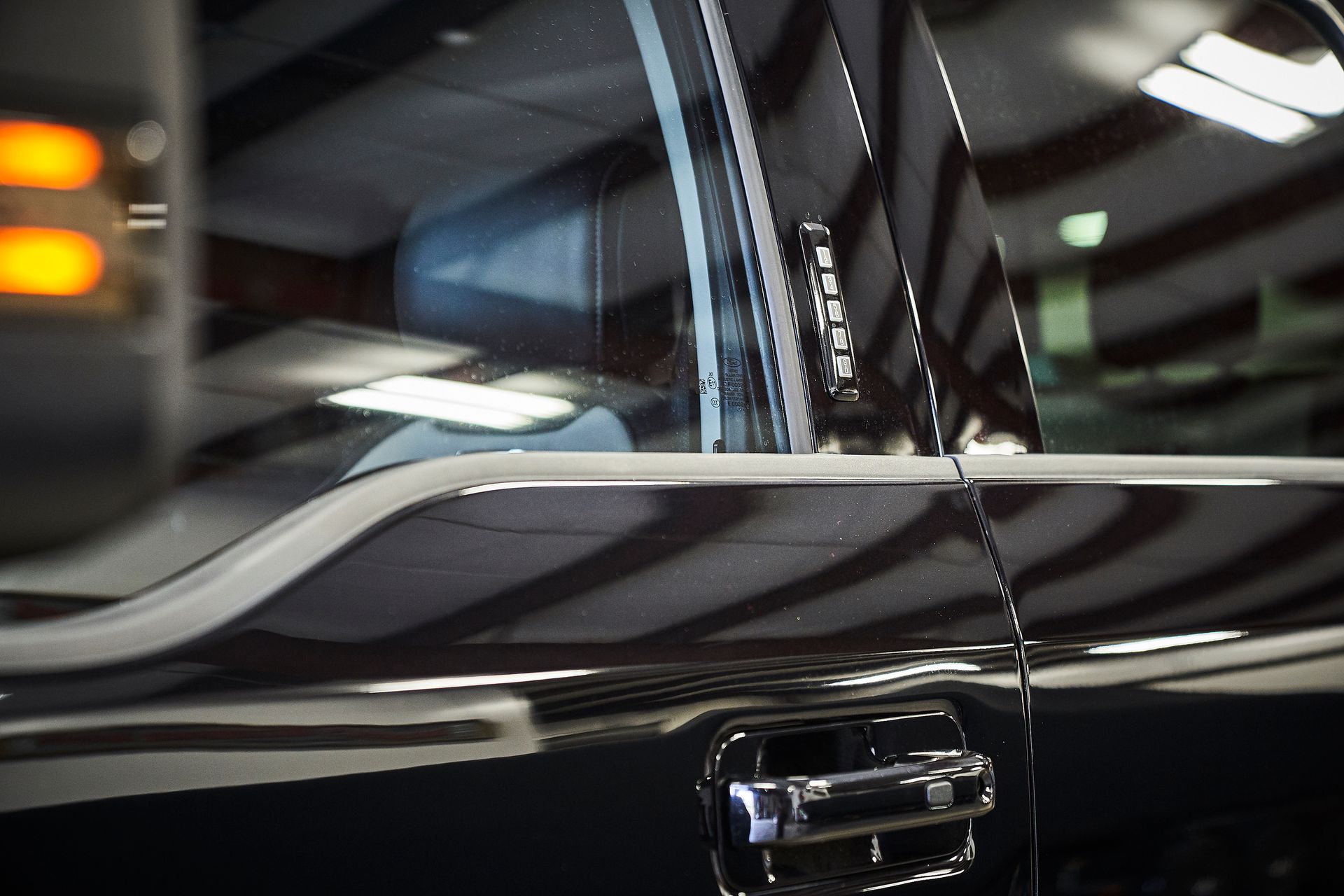 A black car is parked in a garage with the door open