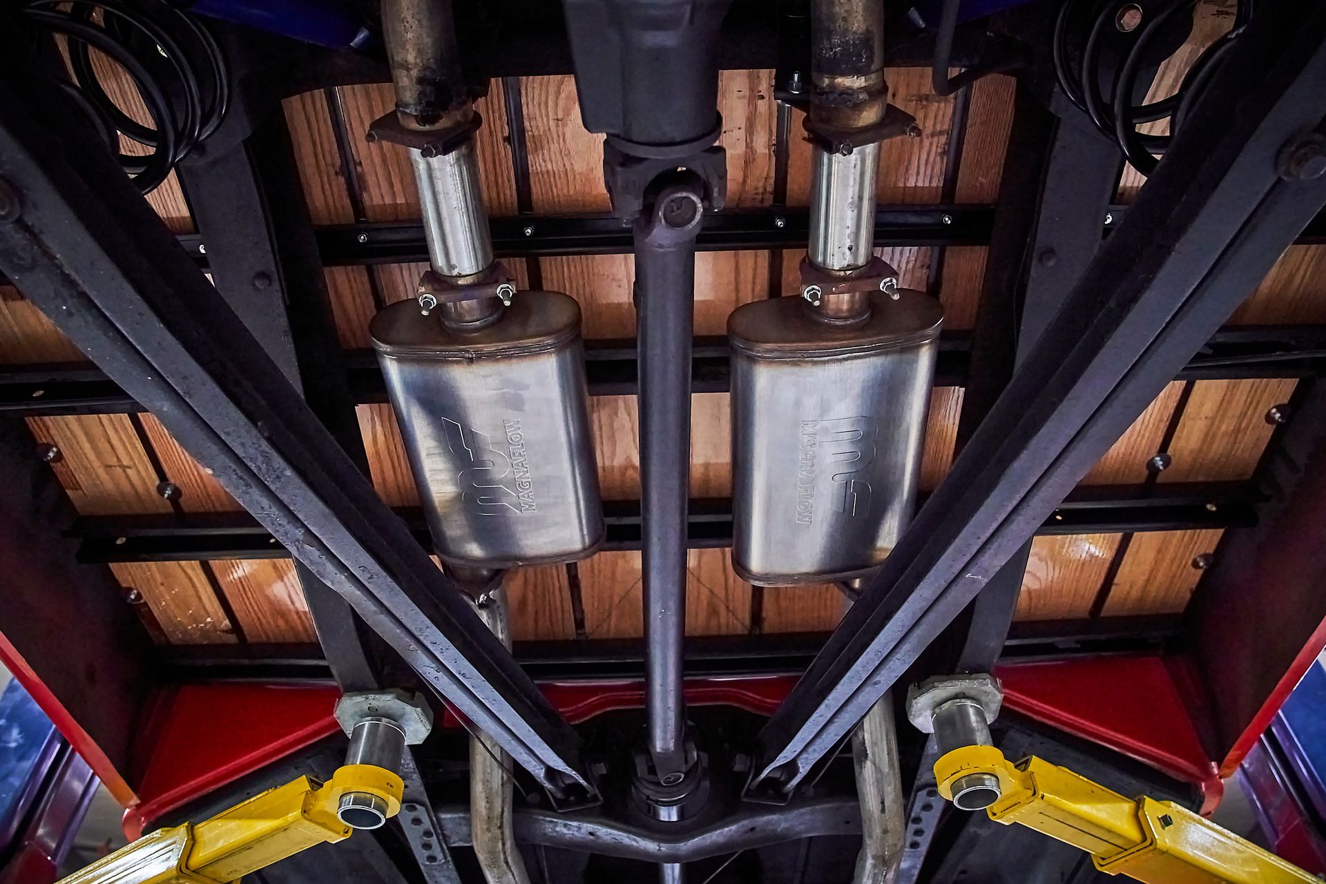 A close up of the underside of a truck with exhaust pipes.