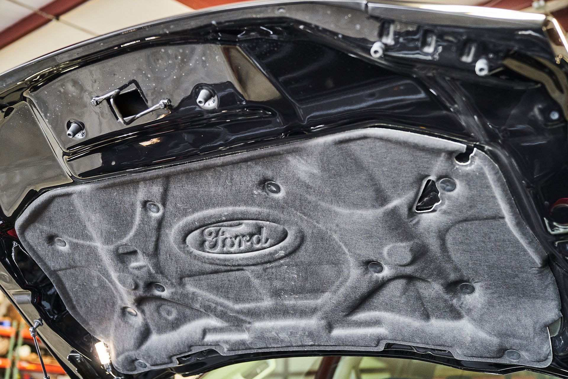 The hood of a black ford car is open