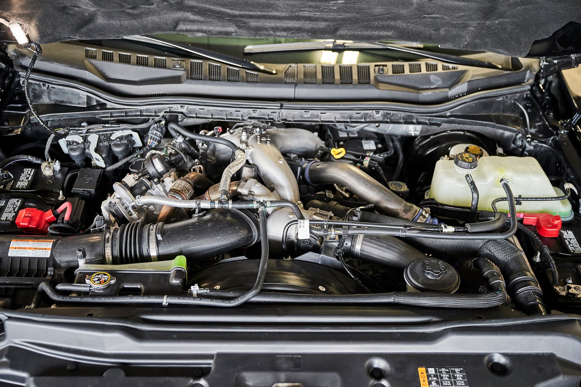 A close up of a car engine with the hood open.