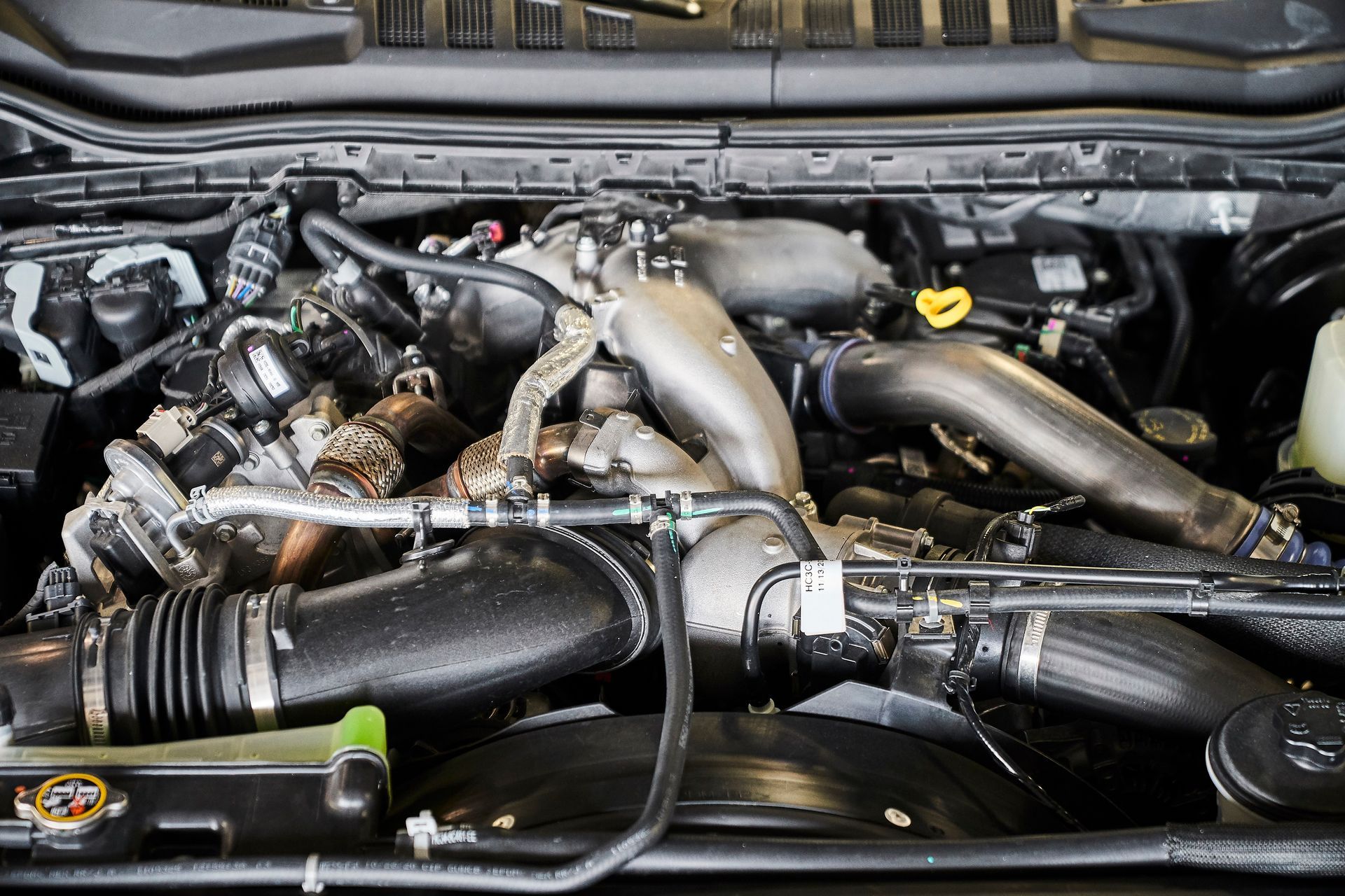 A close up of a car engine with the hood open.