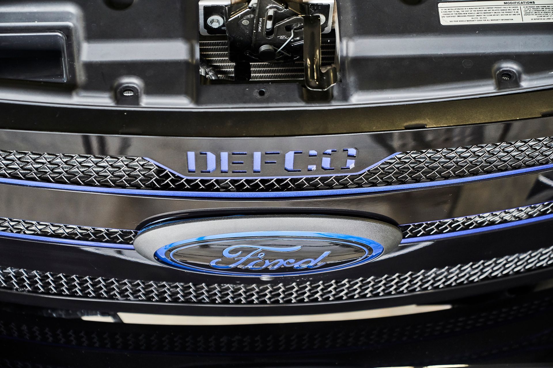 A close up of a ford logo on the front of a car