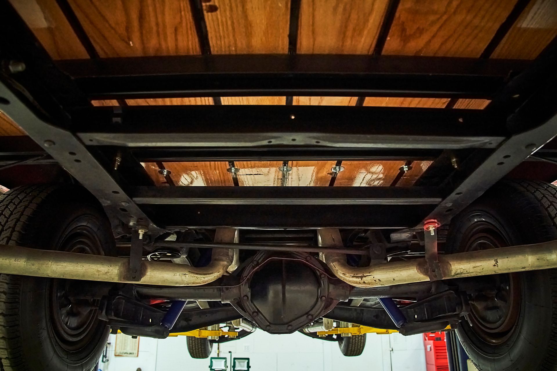 The underside of a truck is shown in a garage.