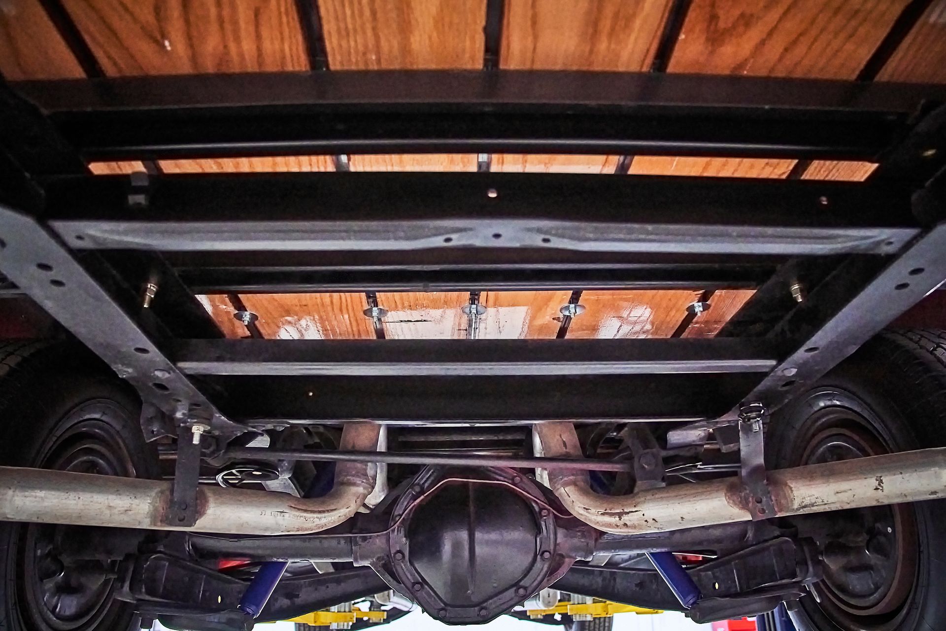 The underside of a truck with a wooden bed