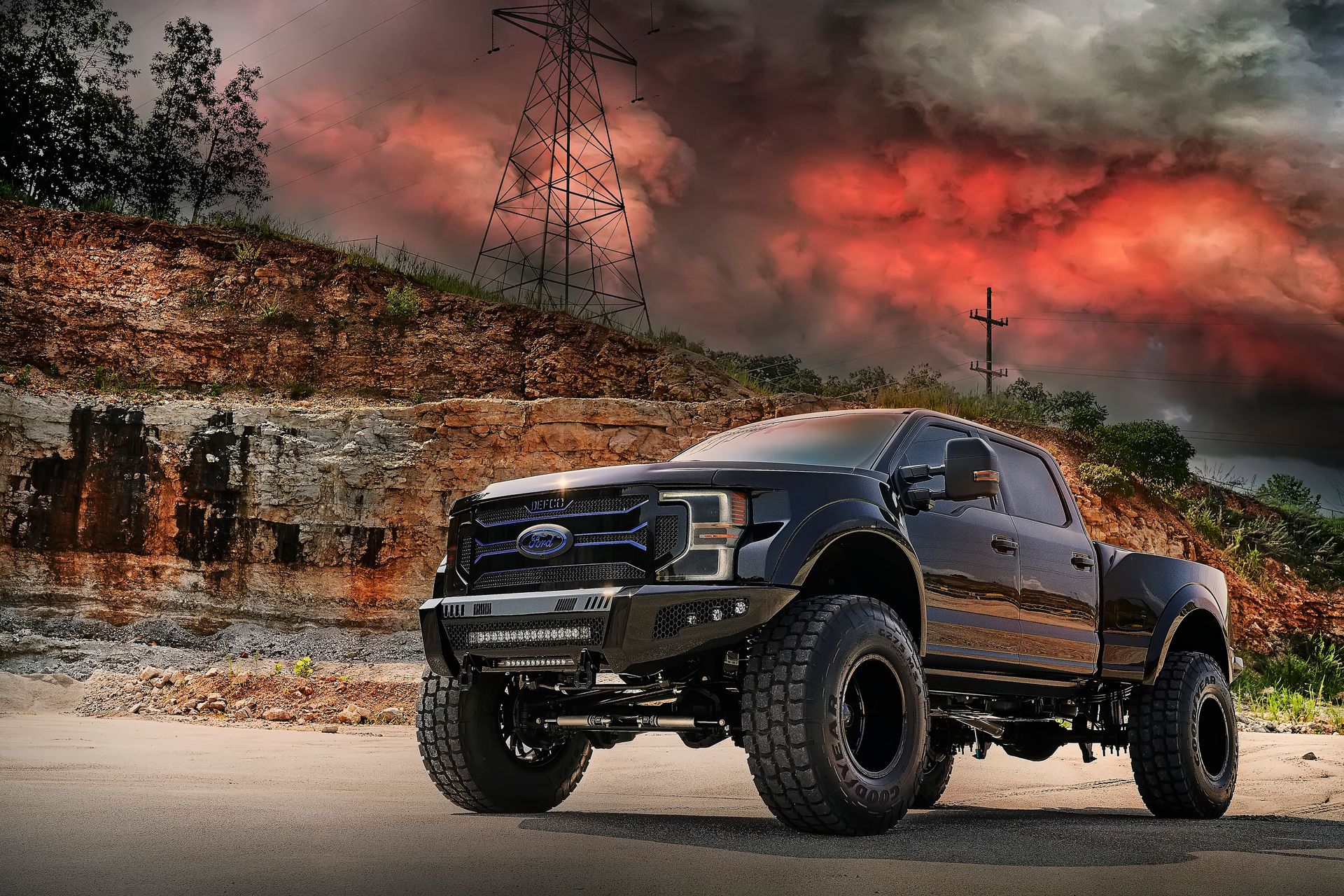 A black ford truck is parked on the side of the road