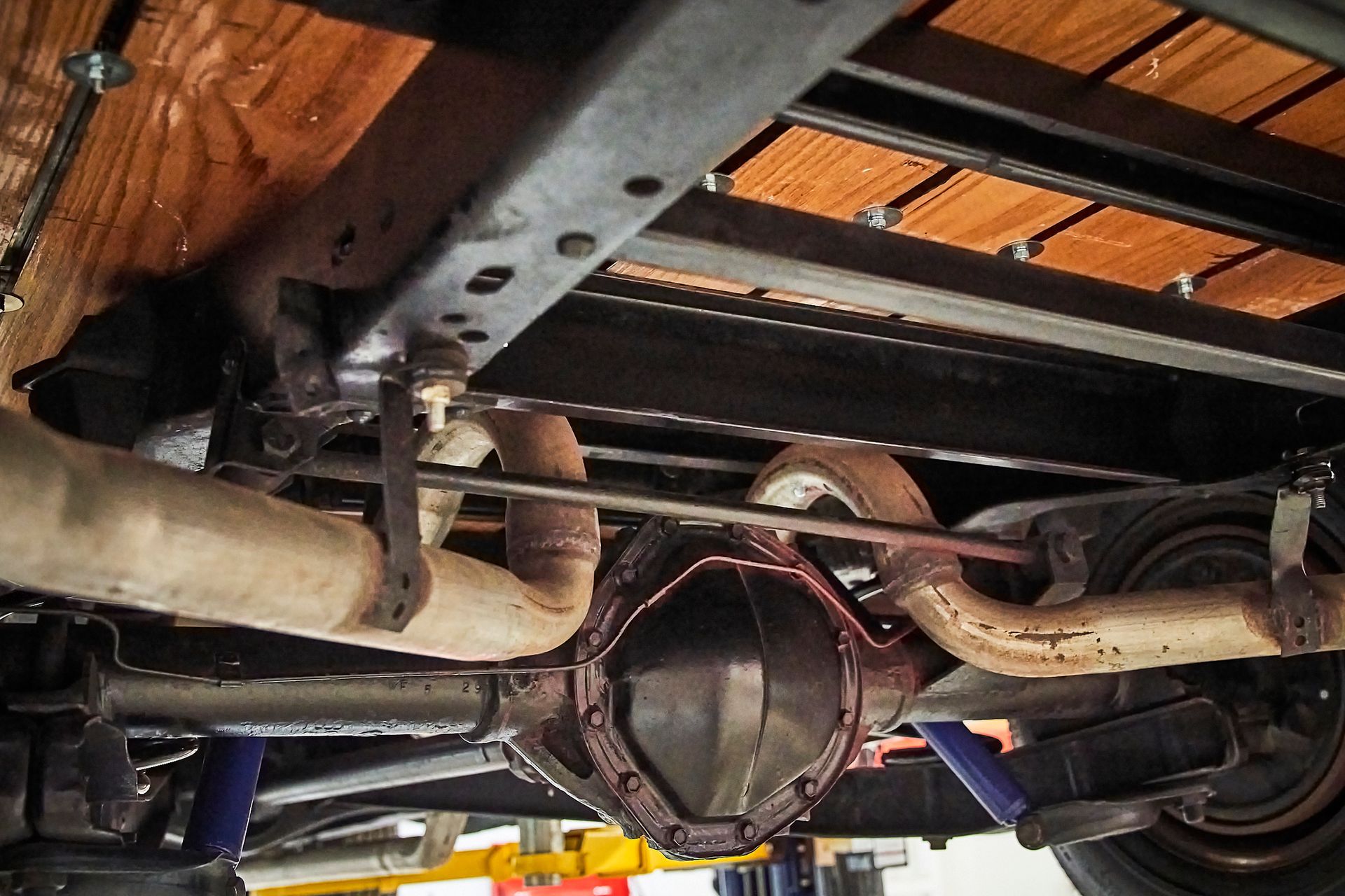 The underside of a truck with a wooden bed