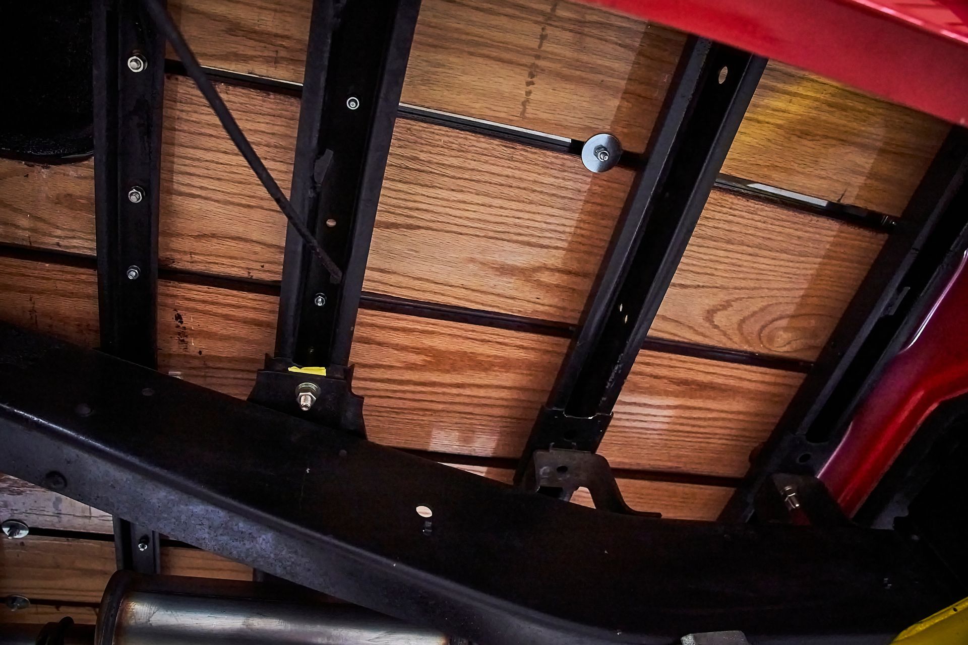 The bottom of a red truck with a wooden bed.