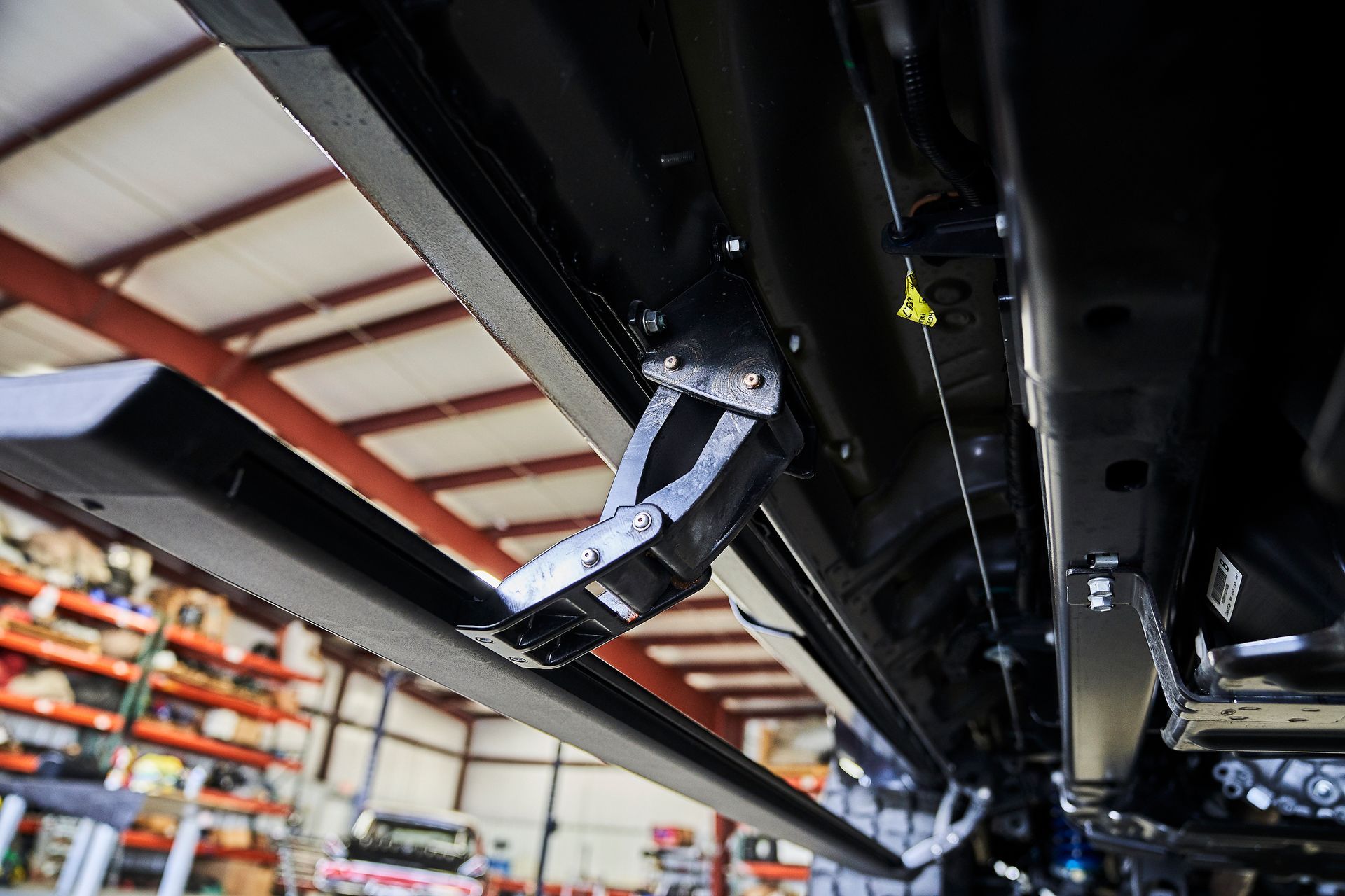 A close up of the underside of a car in a garage.