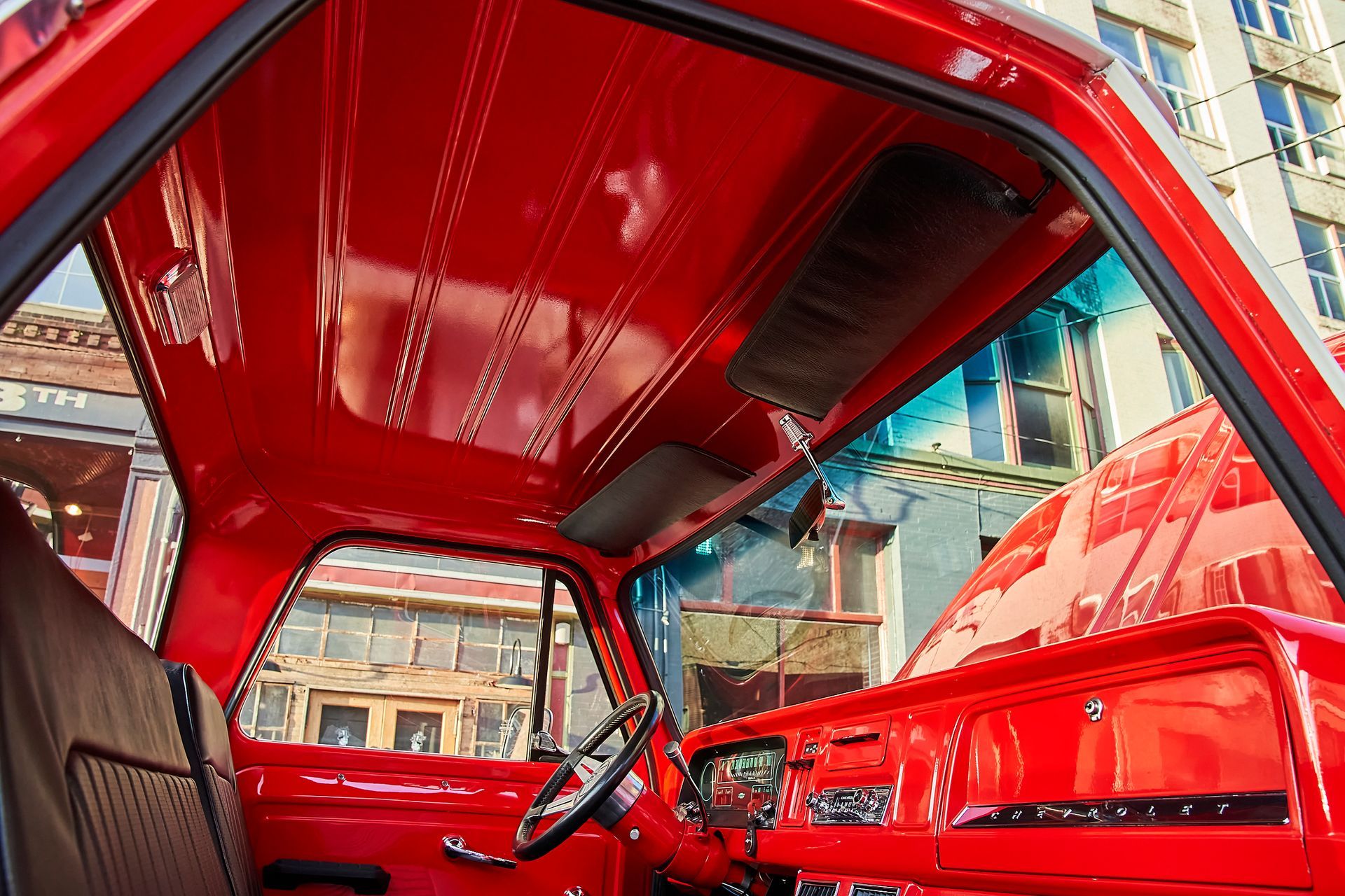 The inside of a red truck with the sunroof open