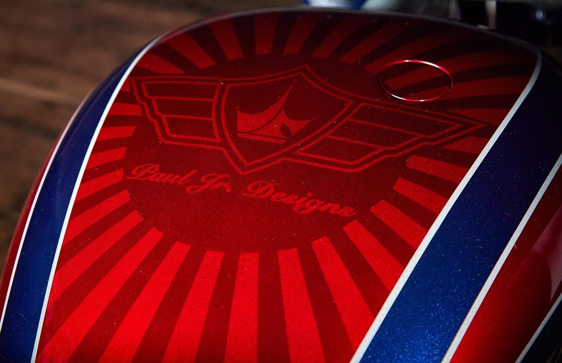 A close up of a red and blue motorcycle tank