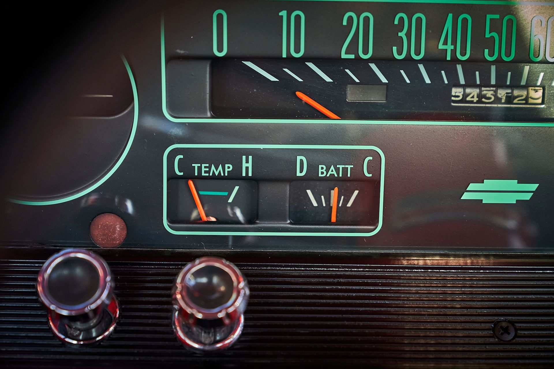 A close up of a car dashboard with a temperature gauge and a battery gauge