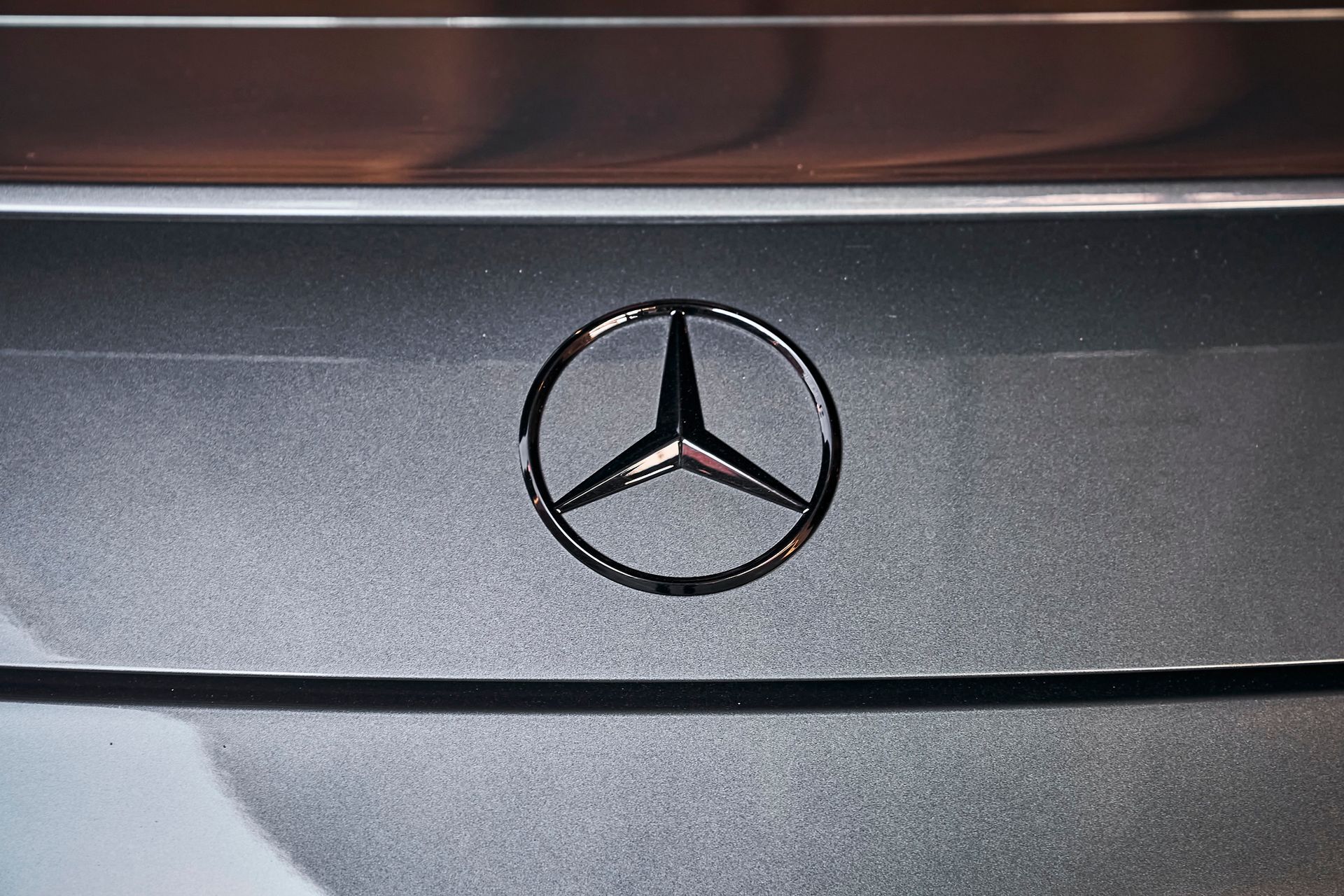 A close up of the mercedes benz logo on the back of a car.