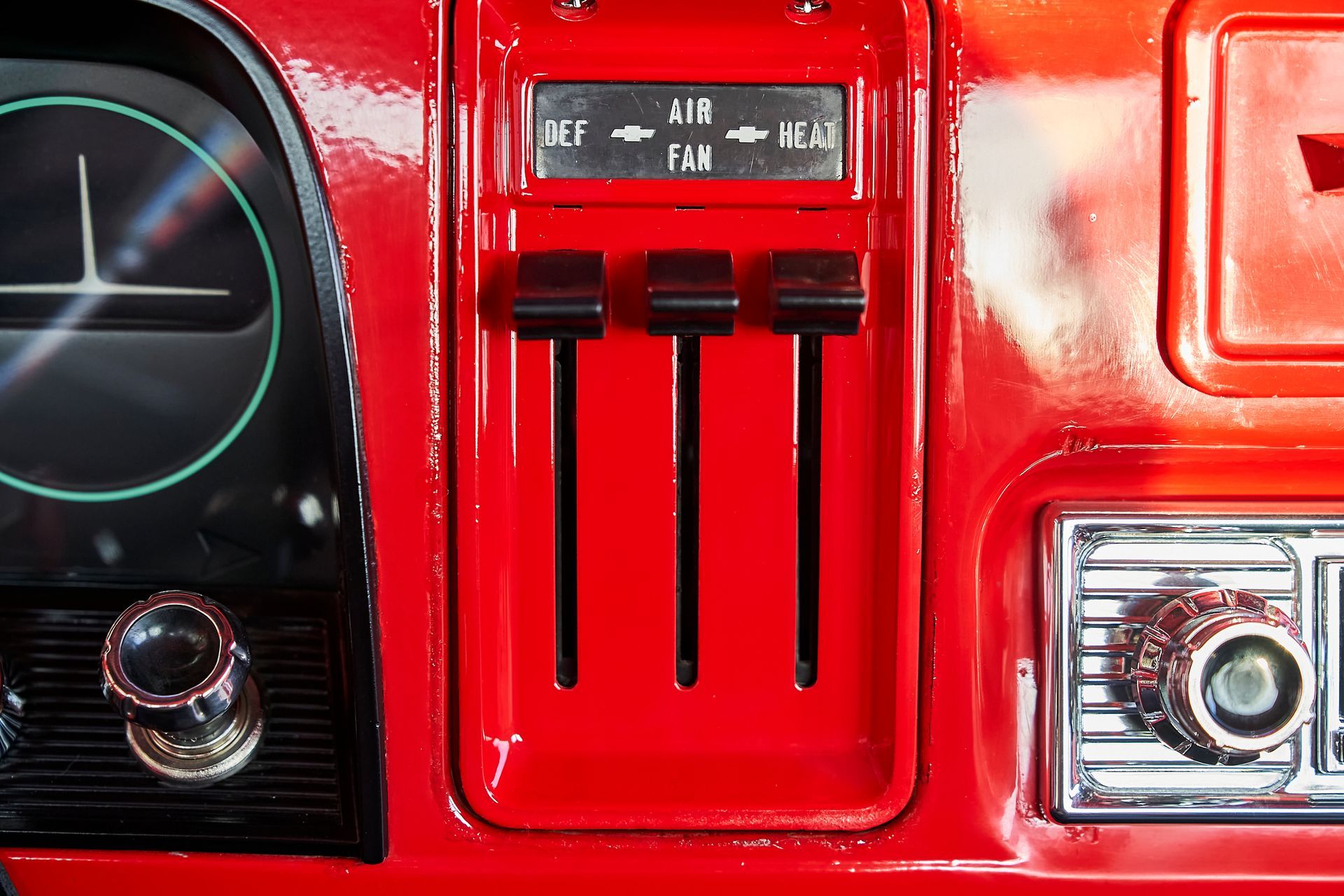 A close up of a red car dashboard with air conditioning controls