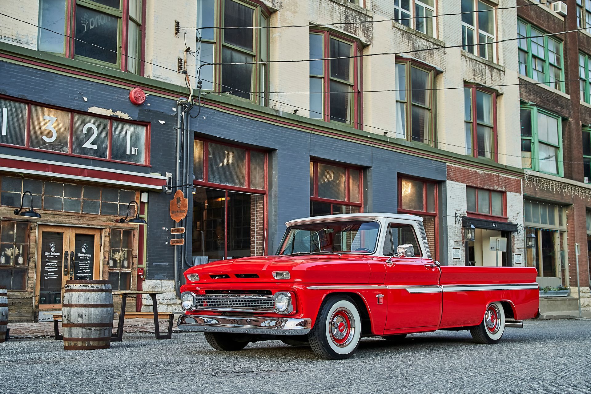 A red pickup truck is parked in front of a building.