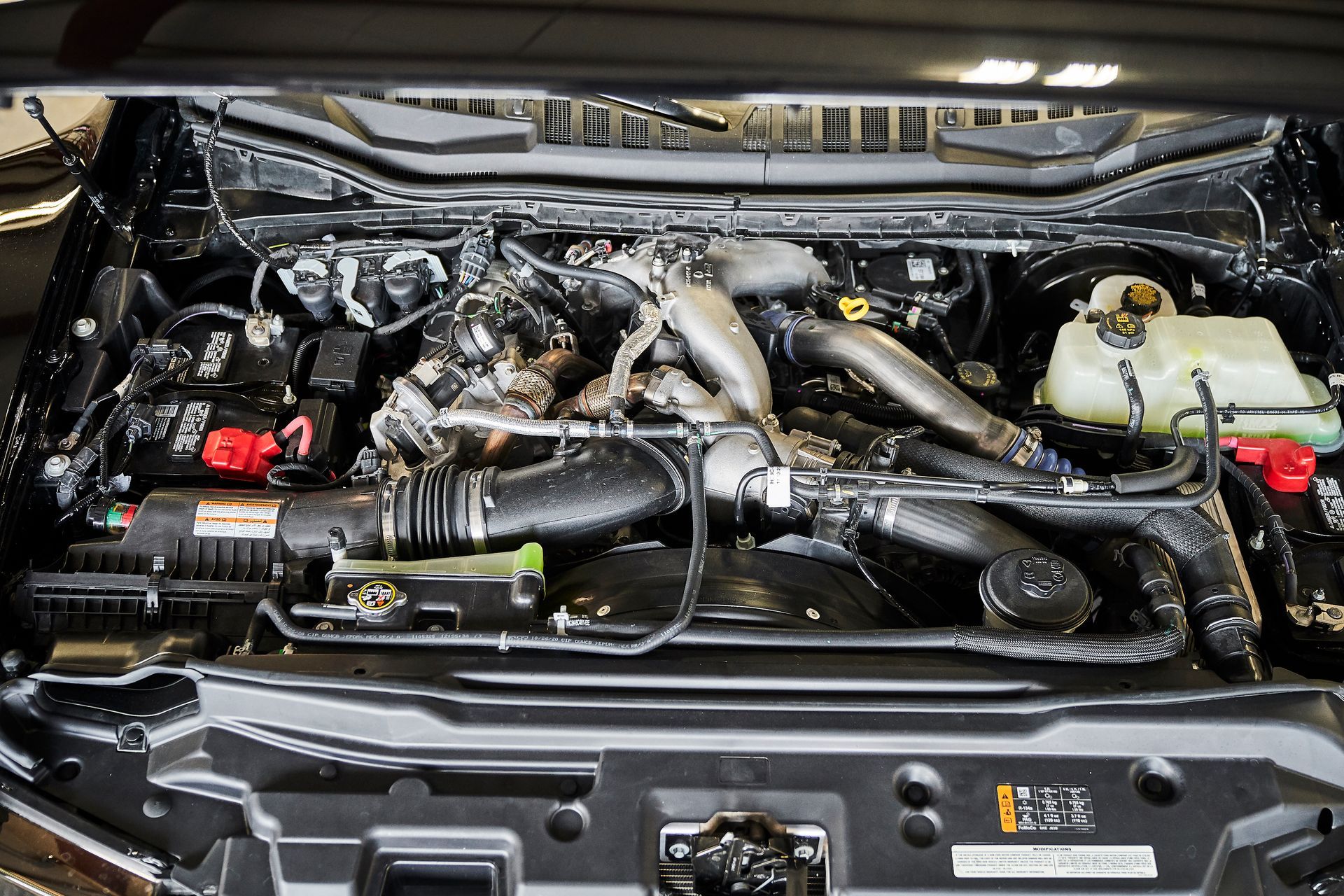 A close up of a car engine with the hood open.