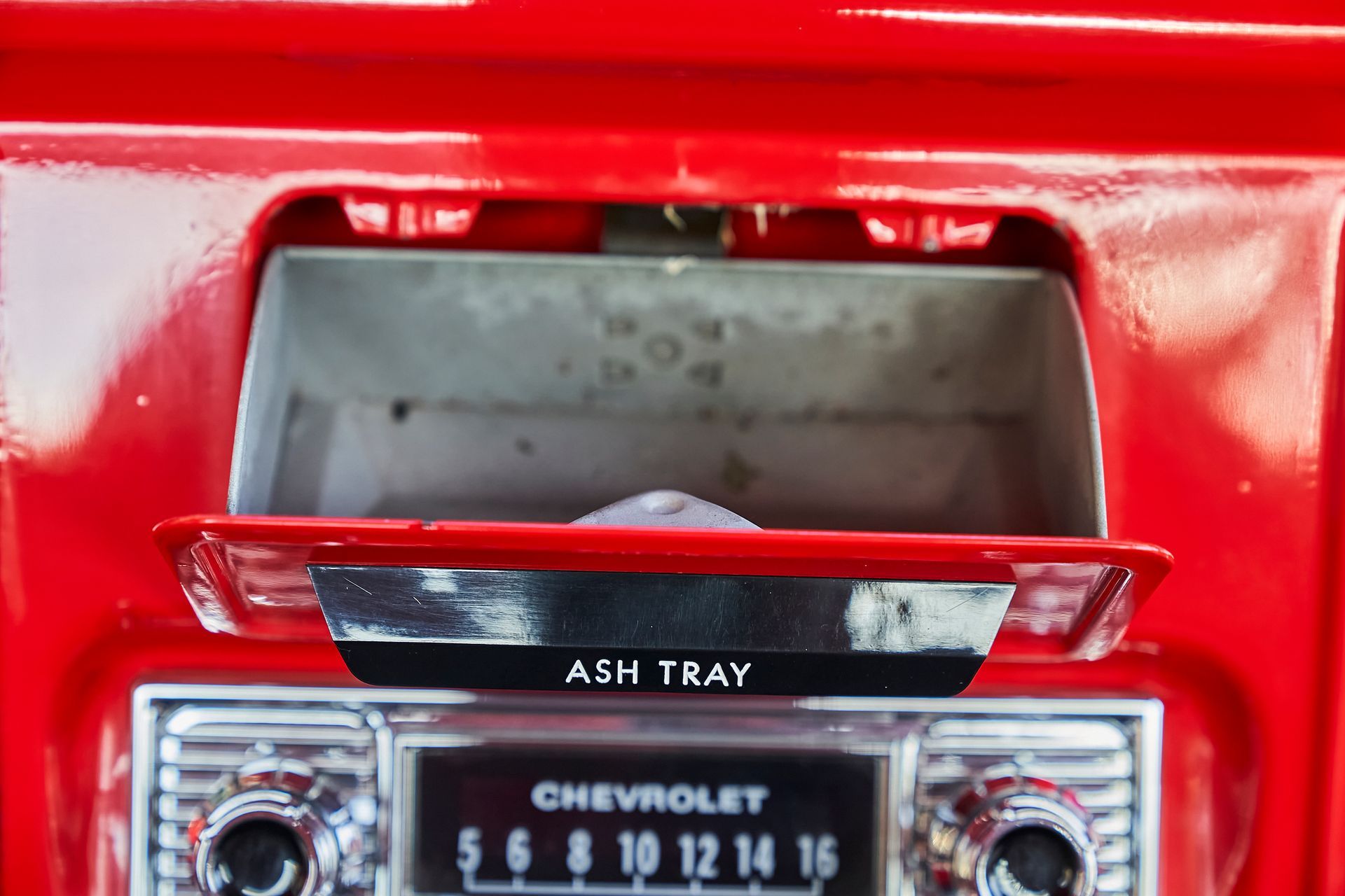 A red ash tray with a chevrolet radio on it