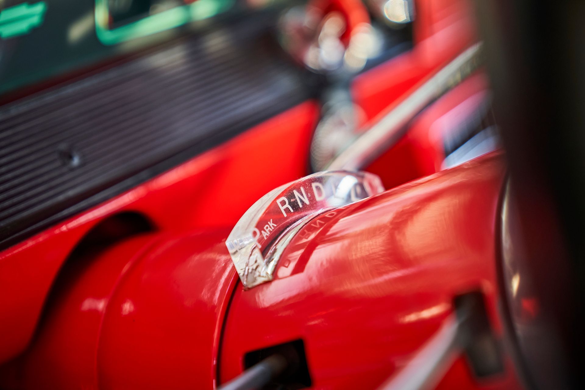 A close up of a red car with a clear shifter.