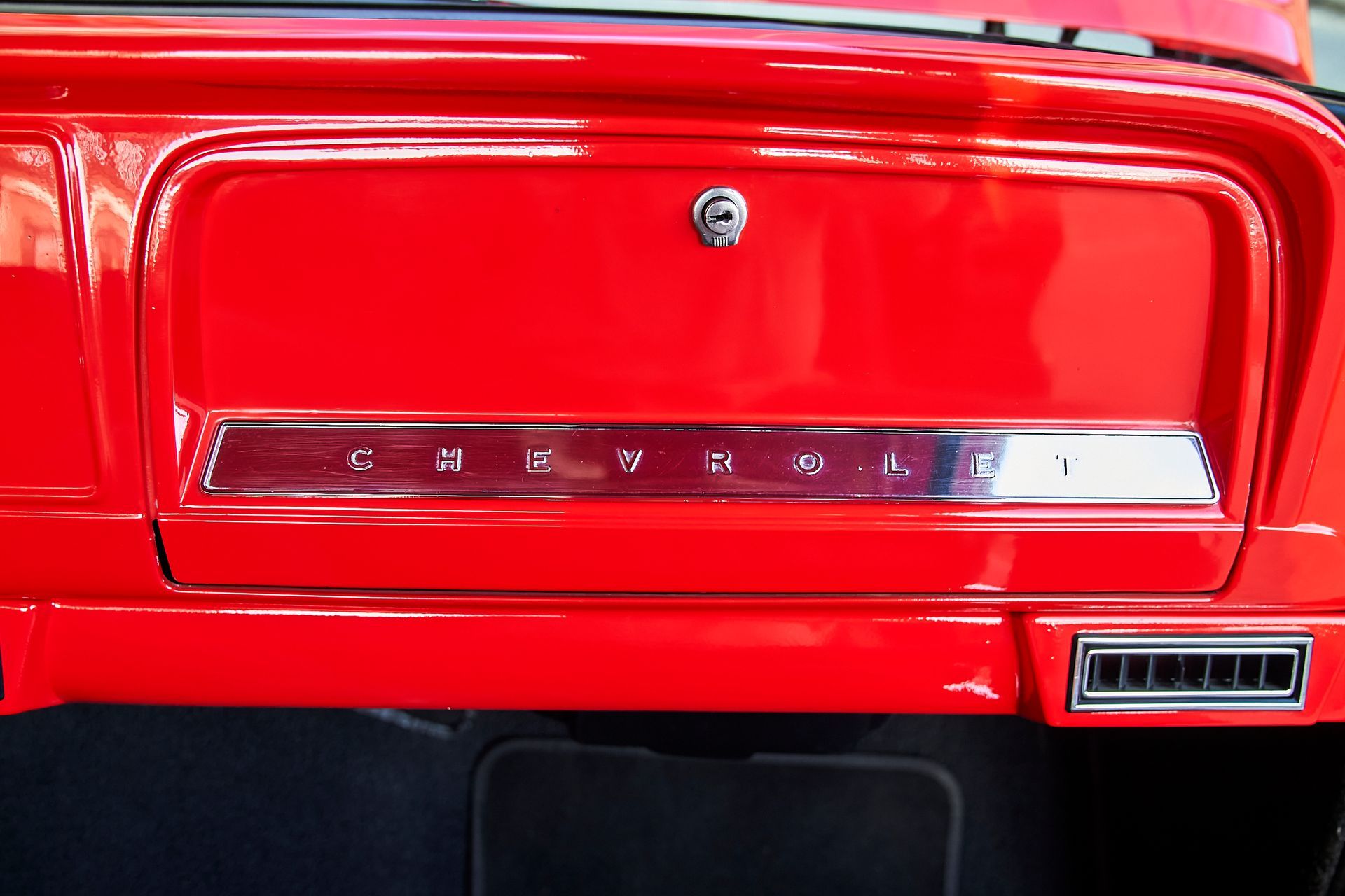 A red car with the word chevrolet on the dashboard