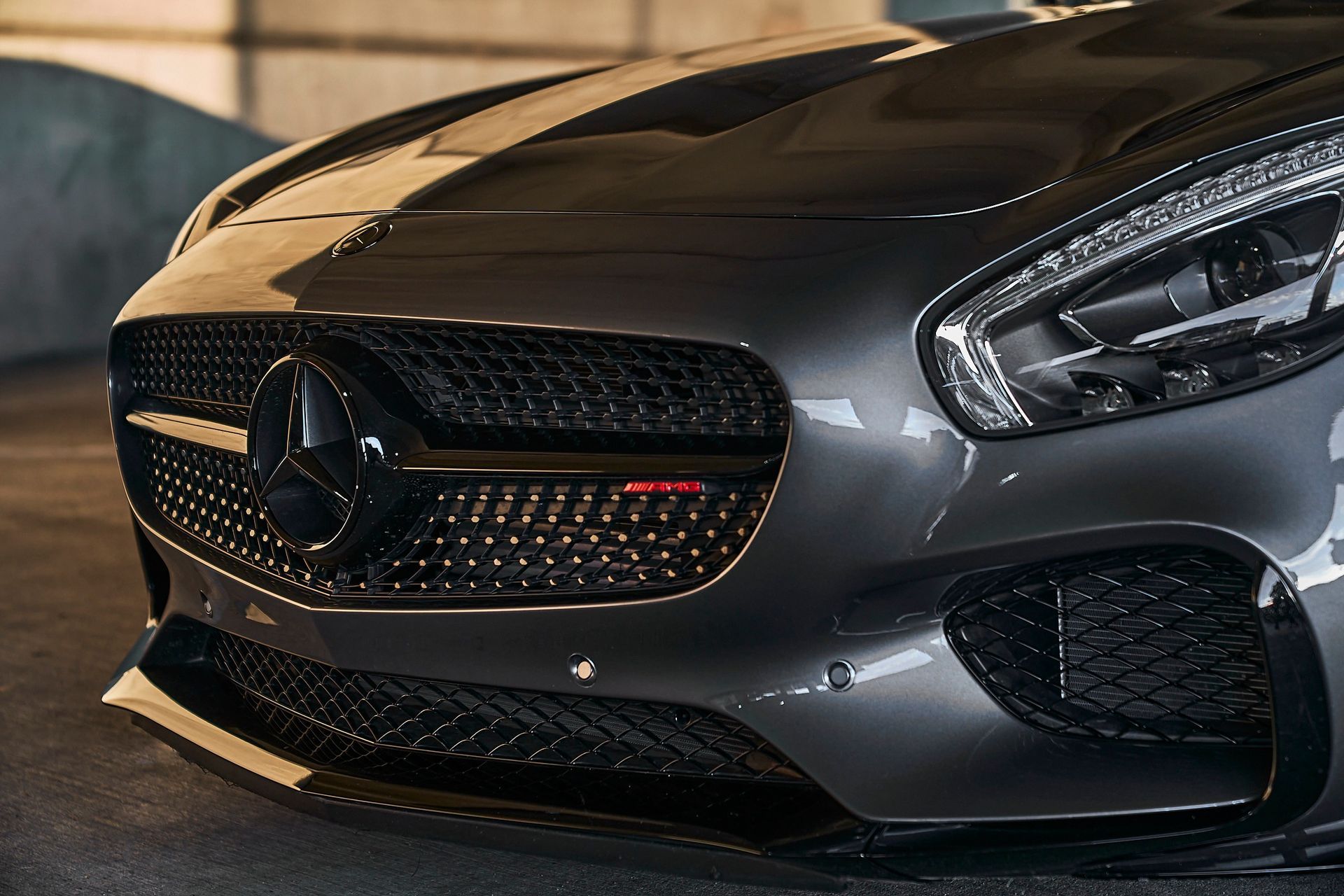 A close up of the front of a mercedes benz sports car parked in a parking lot.