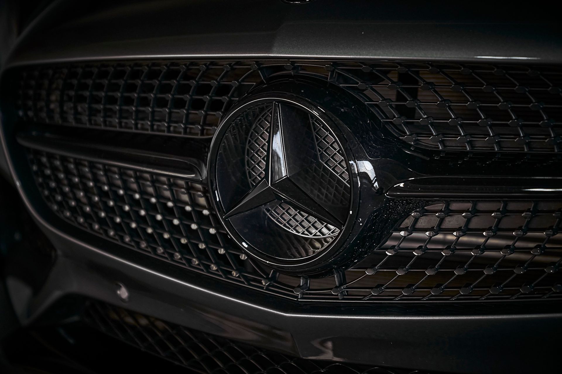 A close up of the mercedes benz logo on the front of a car.