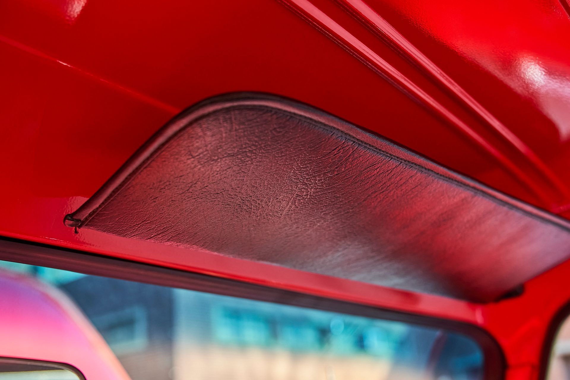 A close up of a sun visor on the roof of a red car.