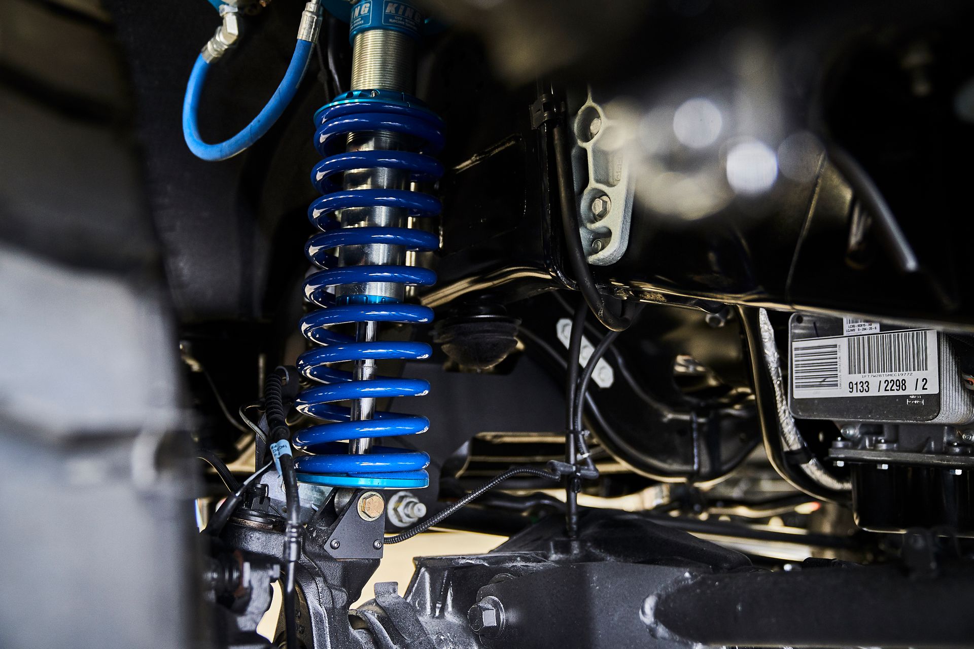 A close up of a blue shock absorber on a car.