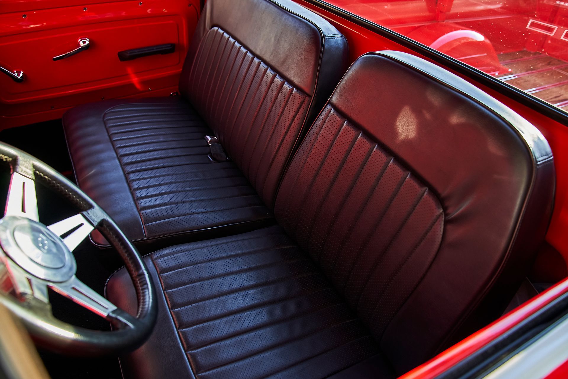 A red car with black seats and a steering wheel
