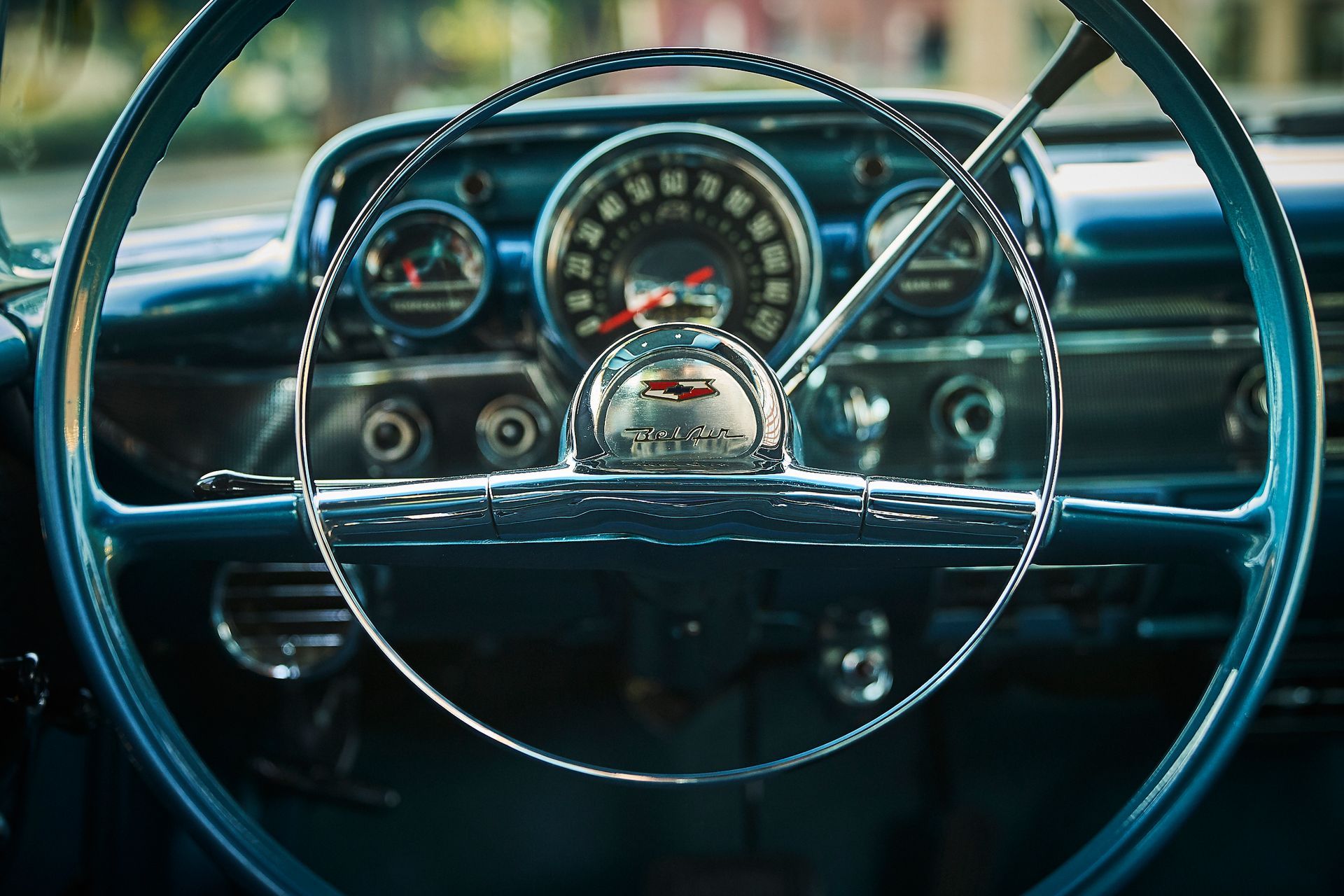A close up of a blue car steering wheel and dashboard