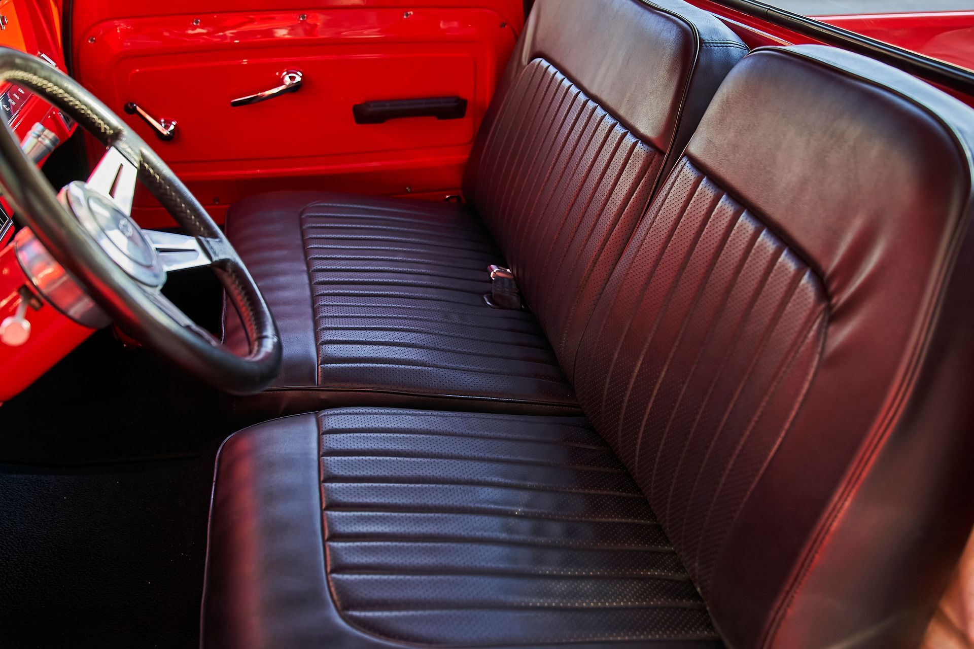 A red car with black leather seats and a steering wheel