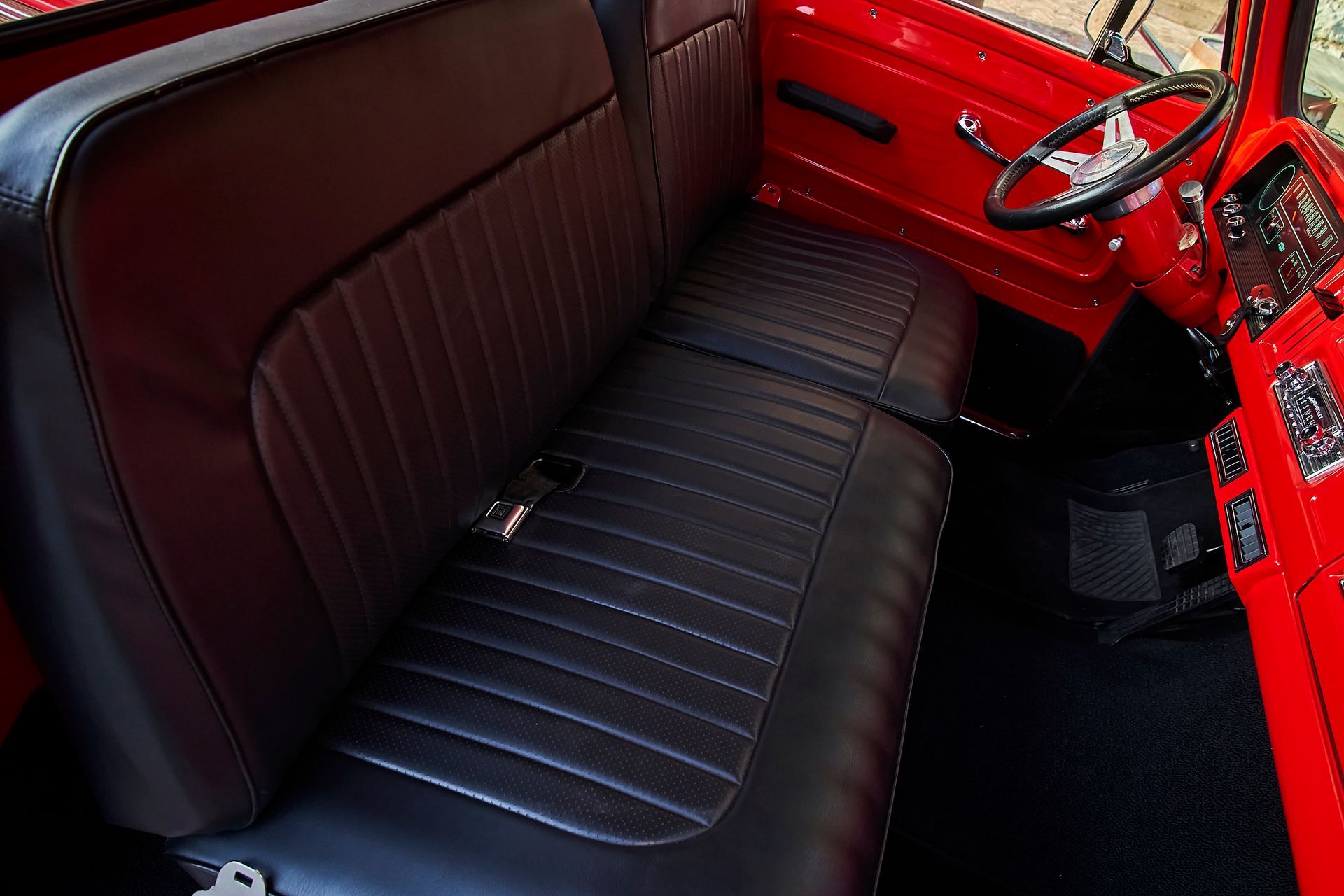 A red truck with black seats and a steering wheel