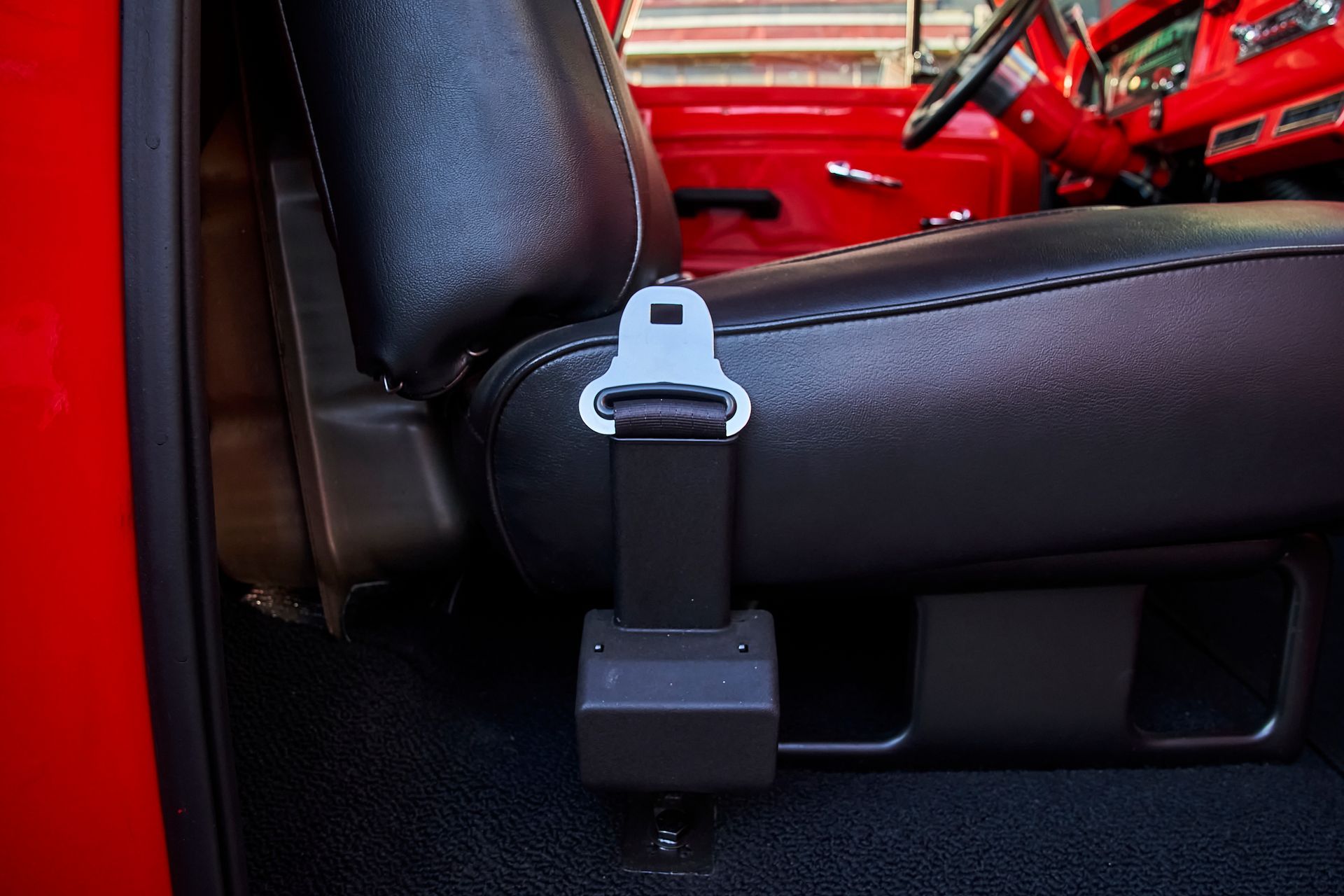 A close up of a seat belt on a red car