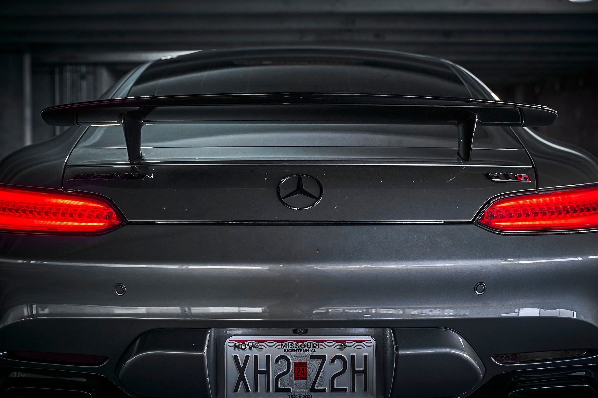 The back of a mercedes benz with a license plate that says xh2 72h.