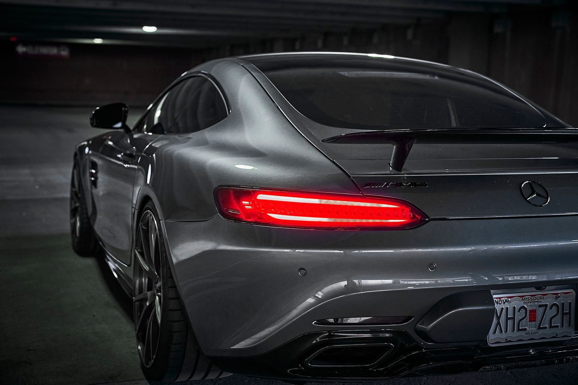The rear end of a mercedes benz amg gt 63 s is shown in a parking garage.