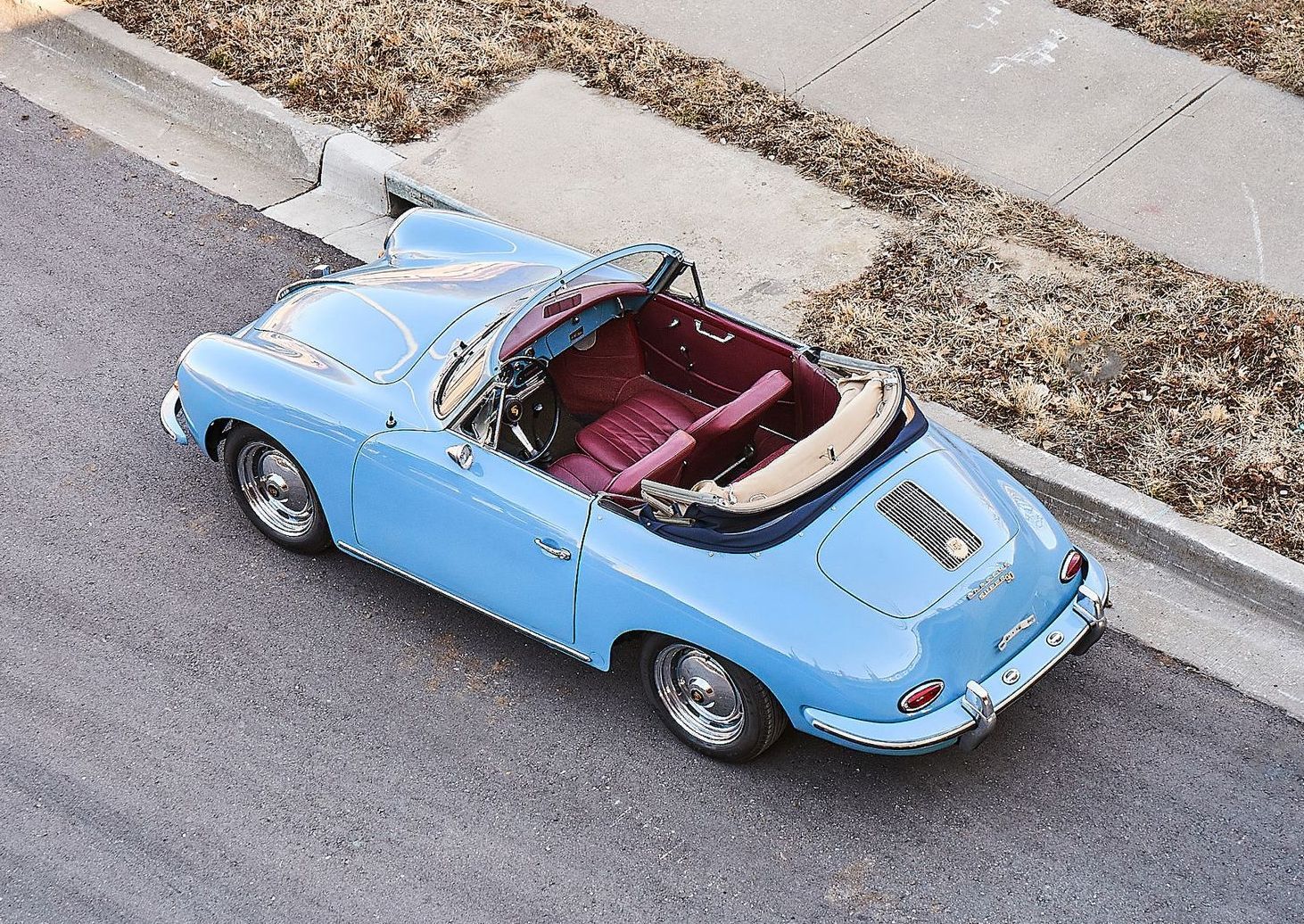 A blue sports car is parked on the side of the road.