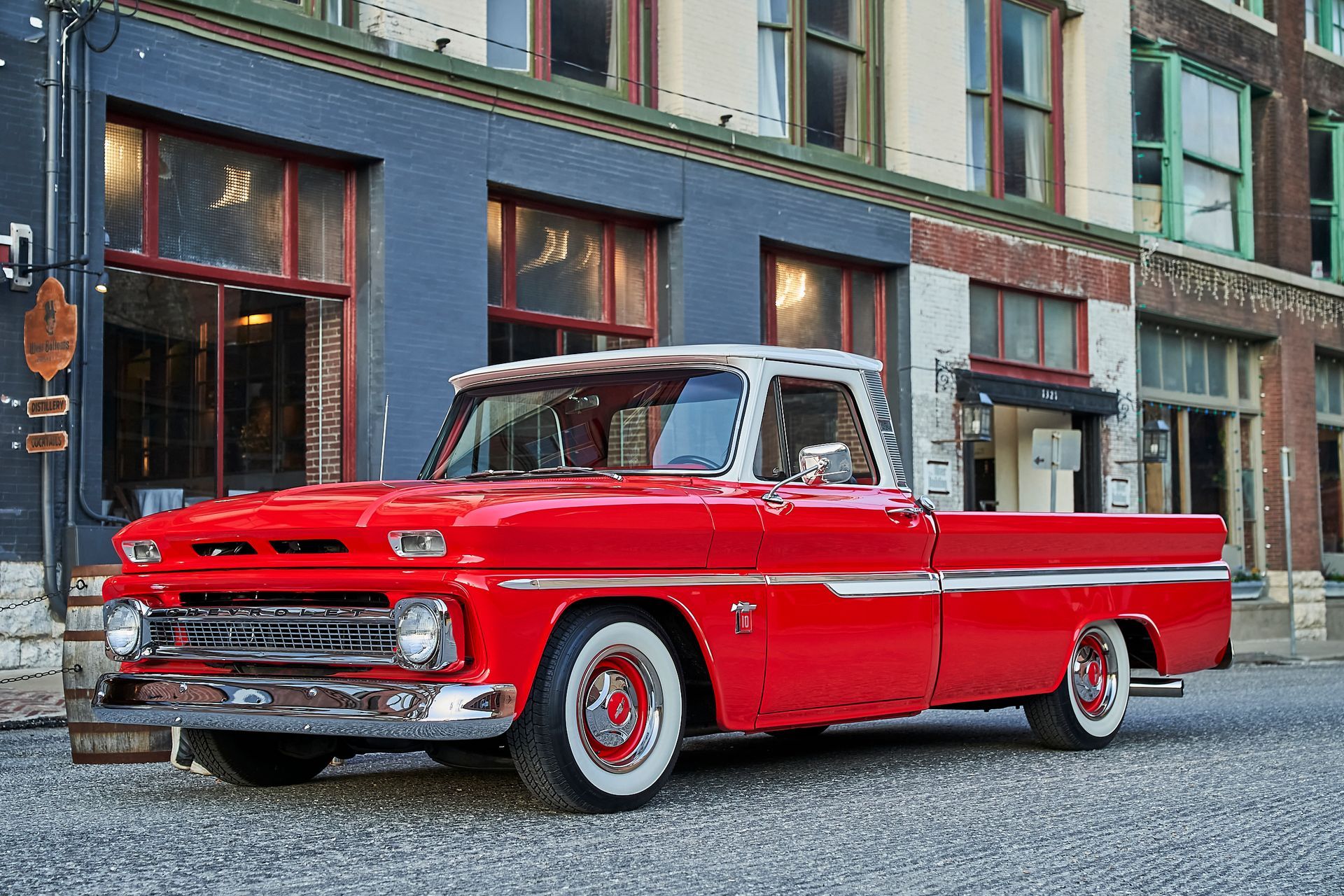 A red pickup truck is parked in front of a building