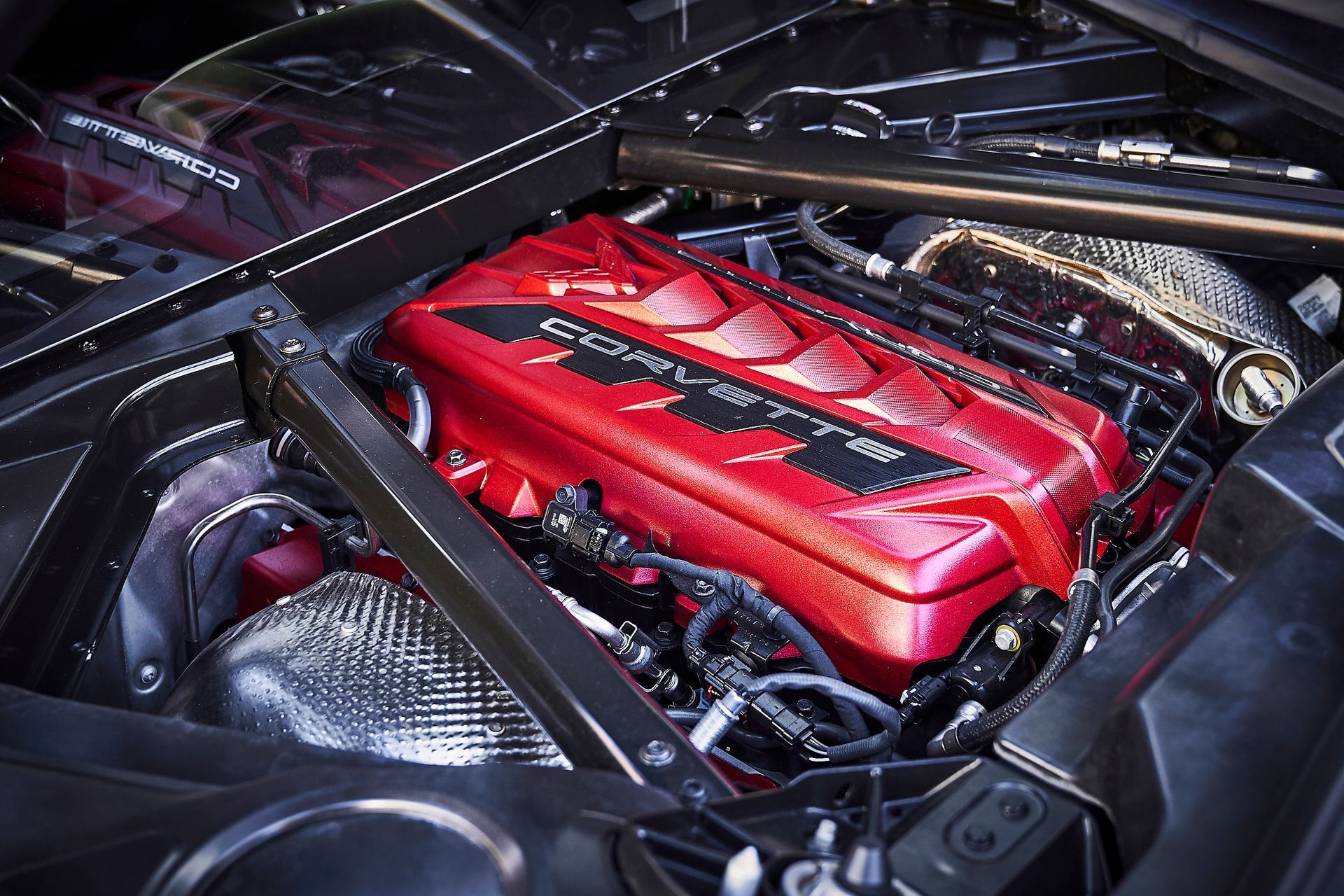 A close up of a corvette engine with a red cover