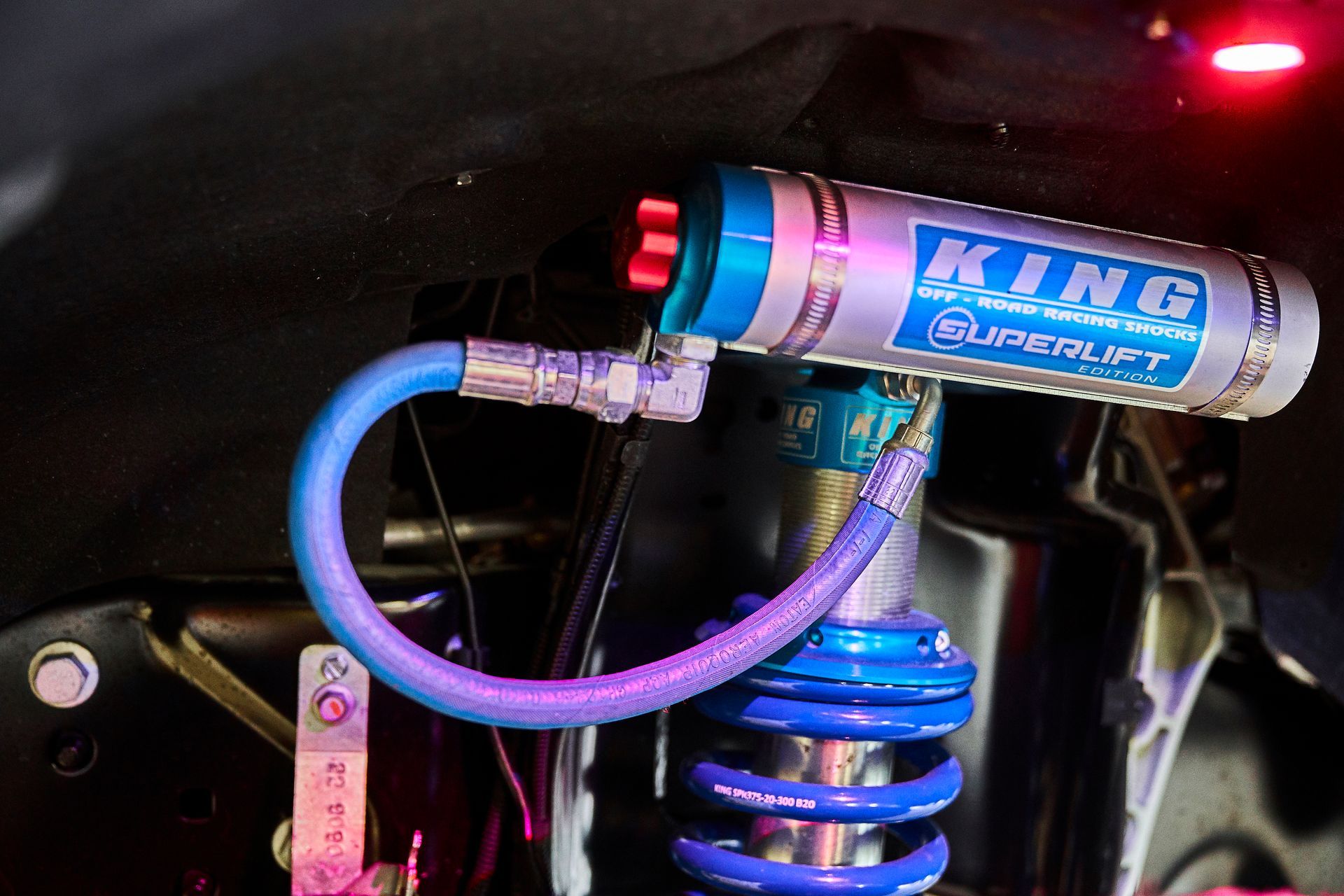 A king shock absorber with a blue hose attached to it