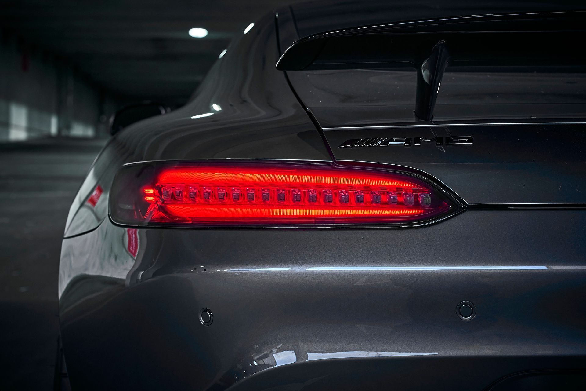 A close up of a car 's tail light in a parking garage.