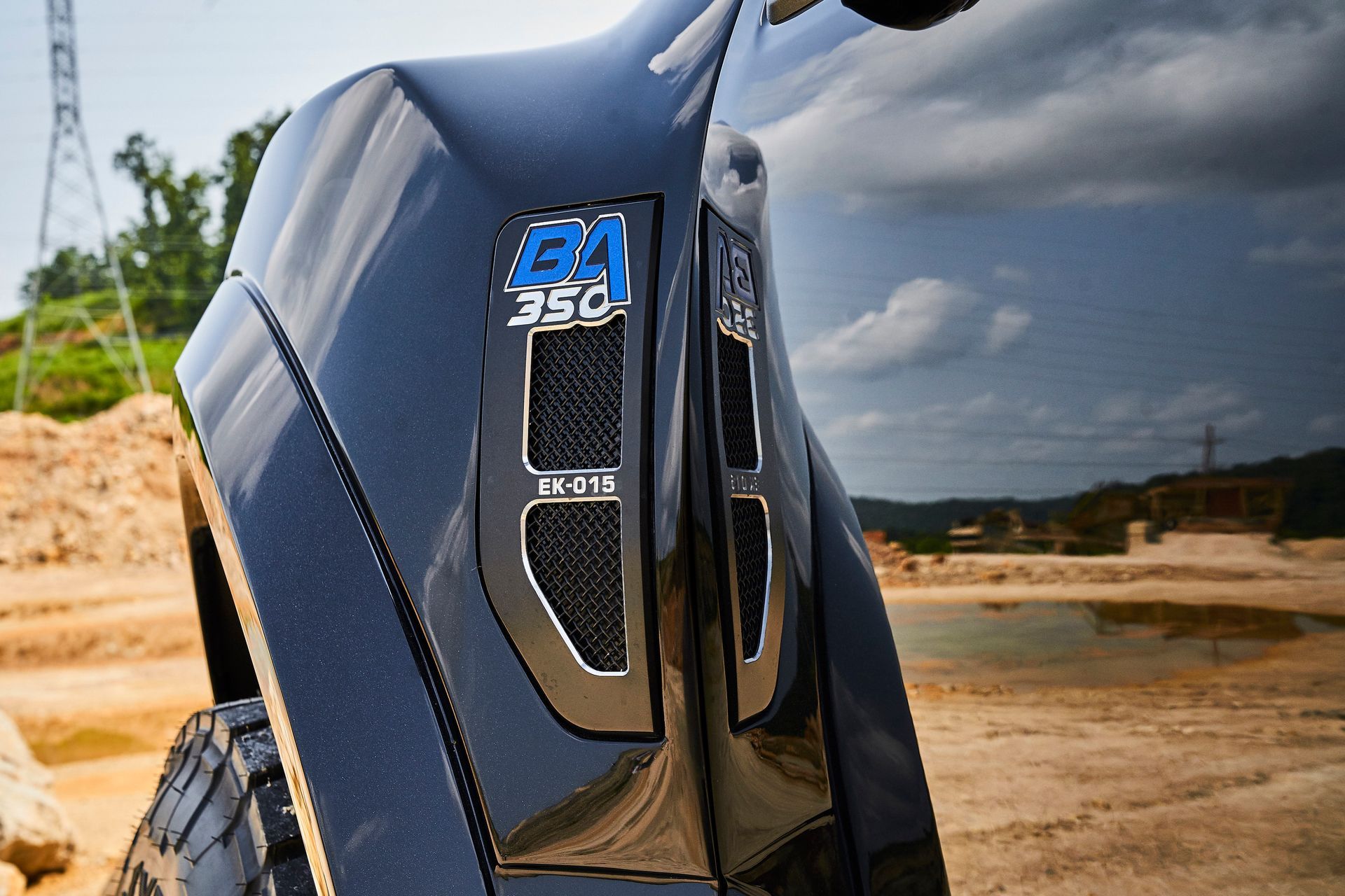 A black ford truck is parked in a dirt field