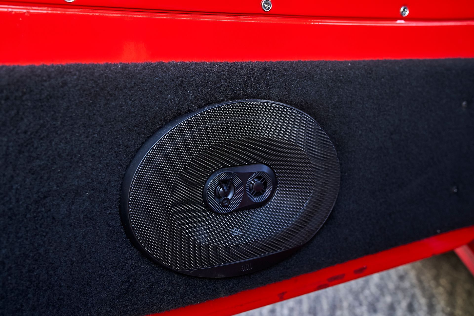 A close up of a speaker in a red car