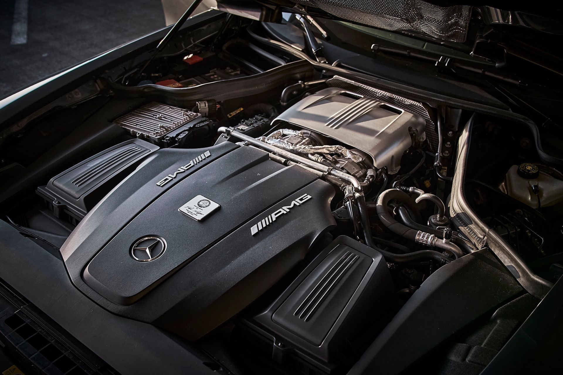 A close up of a mercedes engine with the hood open